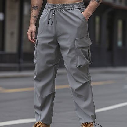 Unisex adult cargo pants with flap pockets, drawstring waist, and solid color.