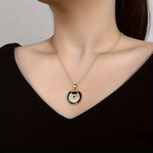 A chic pendant necklace showcasing a jet-black round disc dripping with oil and plated with sleek metal.