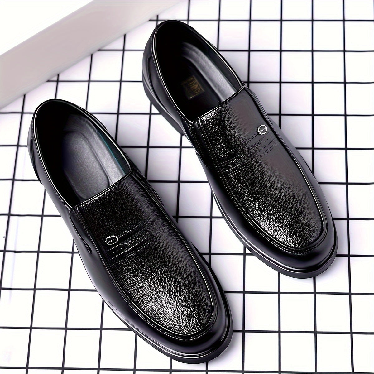 Black slip-on loafers for men featuring a rubber sole, round toe, and embossed logo - perfect for casual attire.