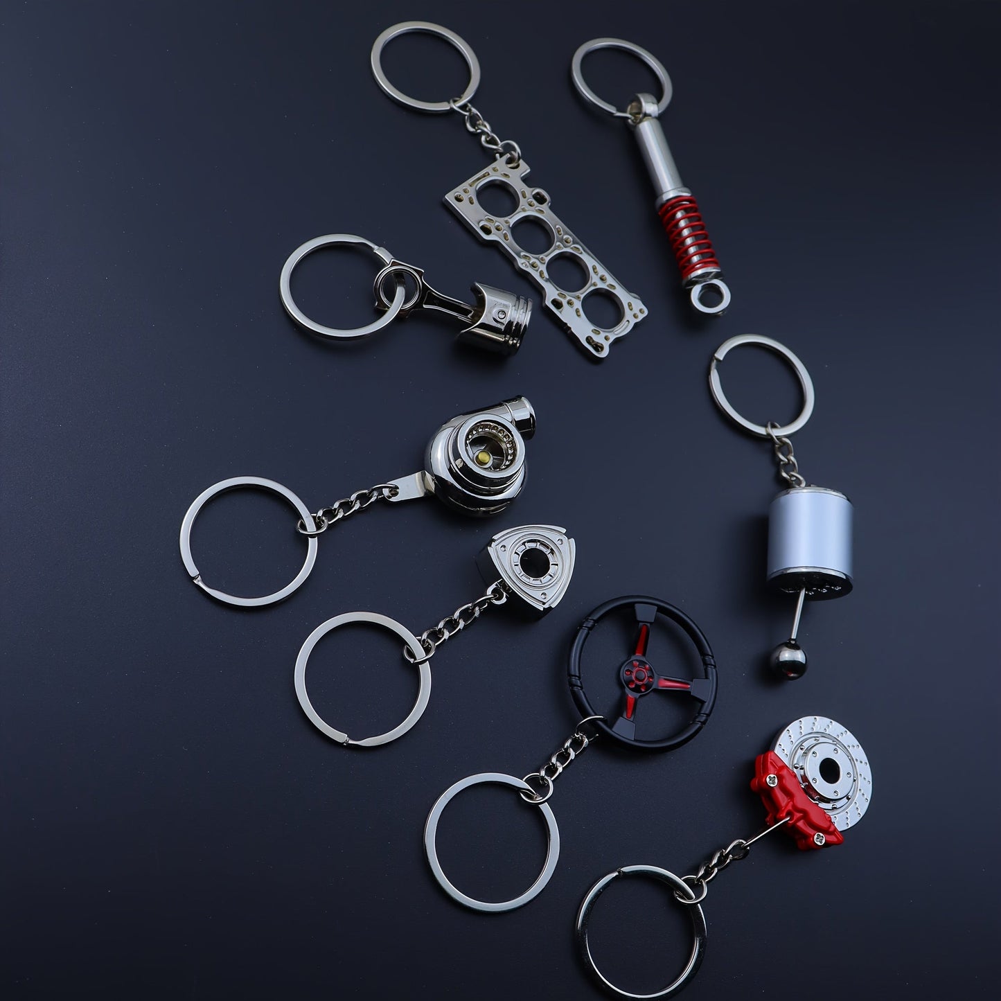 Keychains for creative car modifications, including piston, brake disc, gear, turbocharger, small rotor, shock absorber, engine blade, and steering wheel designs. Perfect for car enthusiasts and as a unique gift.