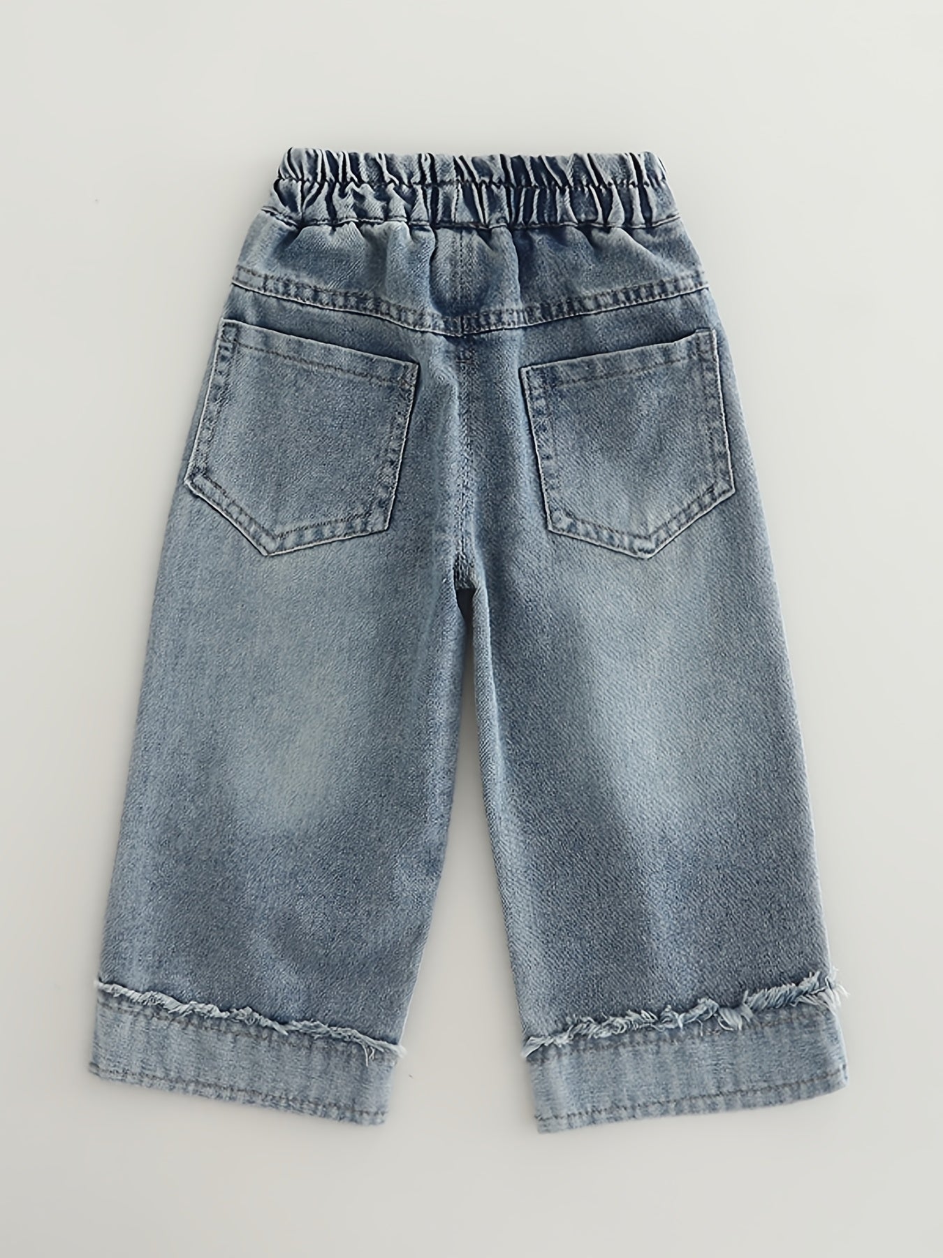 Fashionable loose-fit denim pants for girls, made of rayon blend in a solid color. Machine washable. Suitable for spring/autumn. Ideal for trendy babies. Features long pants.