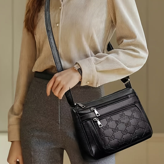 Chic black crossbody bag for women, featuring embossed floral design and bow accent. Ideal for daily use.