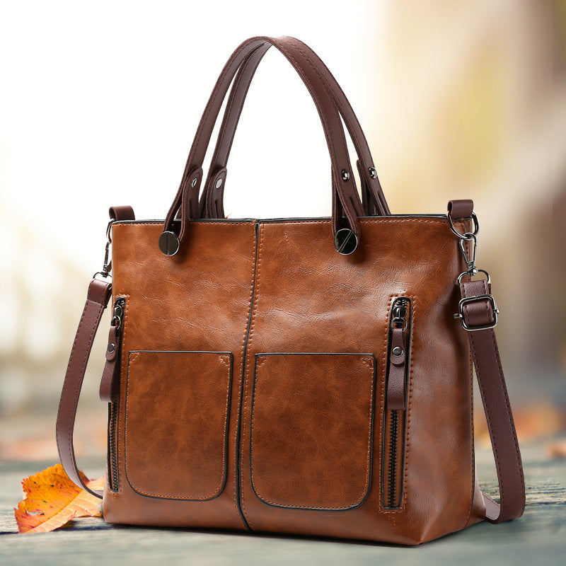 Vintage-style women's tote bag with adjustable strap, large capacity, multiple pockets, zipper closure, deep brown.