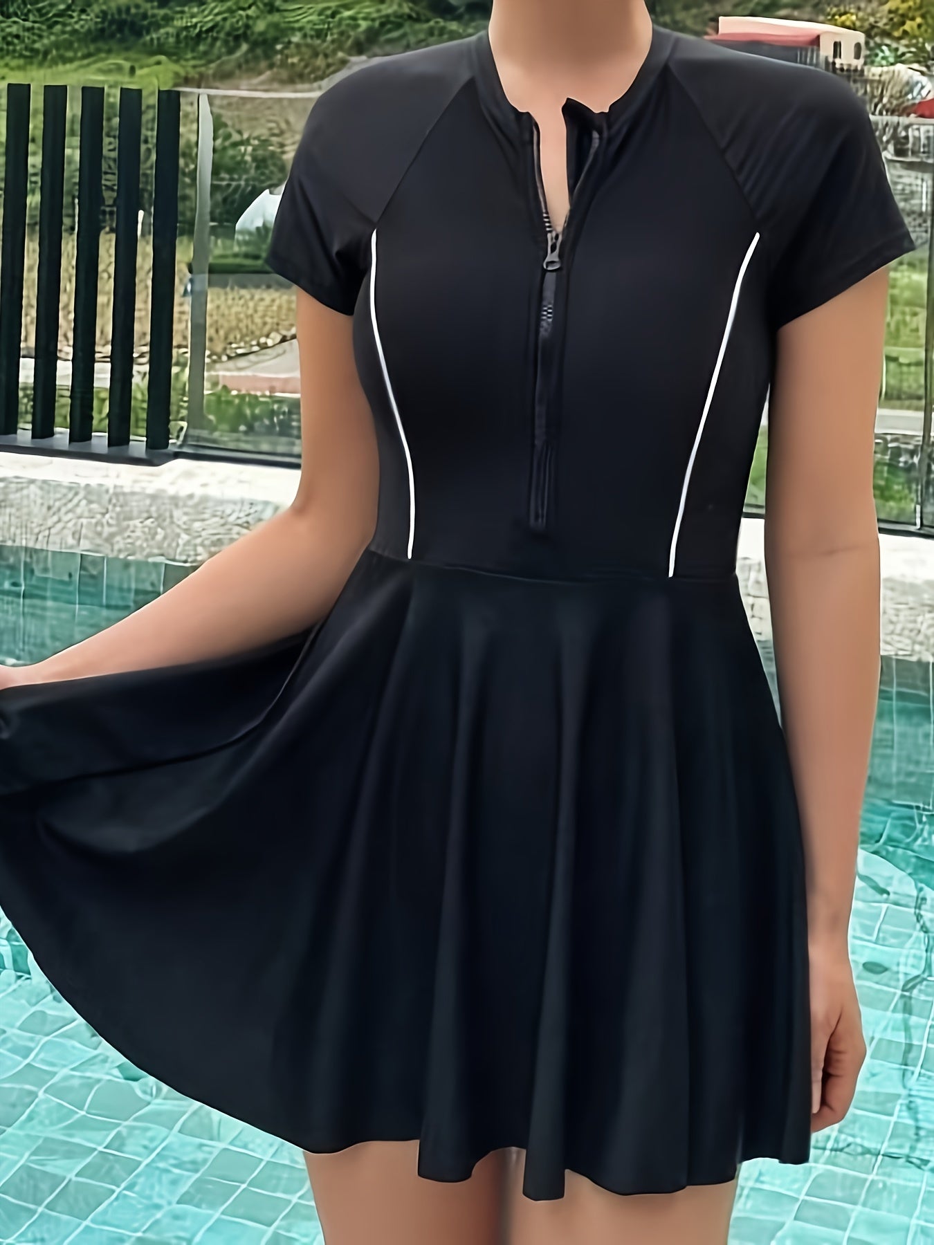 Sporty black one-piece swimsuit for women with zipper detail, made from high stretch nylon/elastane blend. Features short sleeves, round neck, and non-transparent fabric suitable for