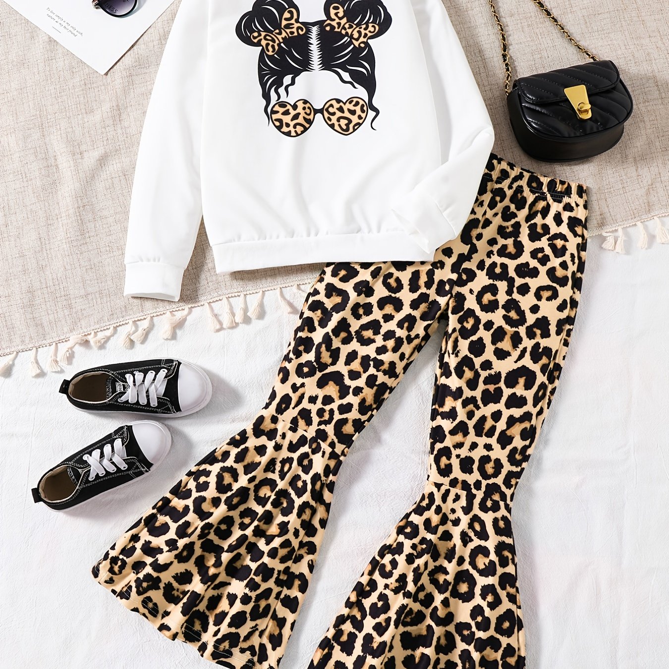 Girls' trendy 2-piece outfit includes a sweatshirt, leopard pattern flared pants, and sunglasses print. Perfect for spring and fall outdoor wear.