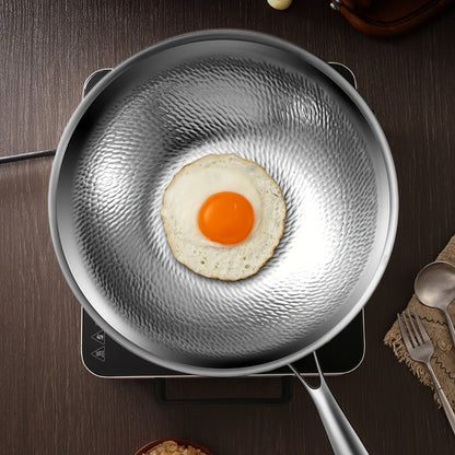 Pure Cook presents the 31.75/33.78cm Titanium-Coated Wok with Lid, featuring Hammered Tri-Ply Stainless Steel. This wok is free from PFOA and PTFE, making it safe for use in dishwashers and ovens.