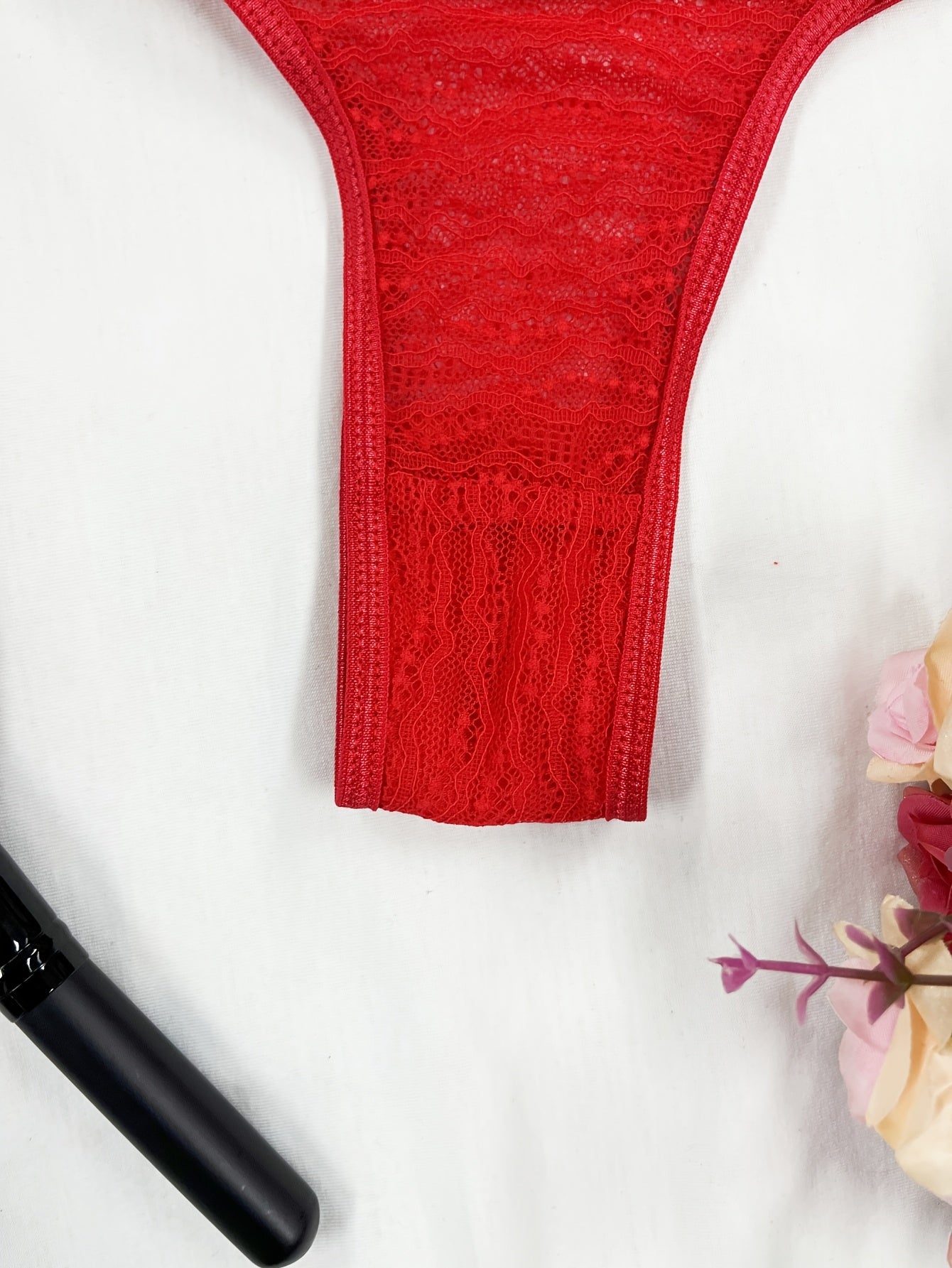 Red lace thong panties for women with floral pattern and scalloped trim. Made of breathable polyester blend that is semi-sheer and hand washable.