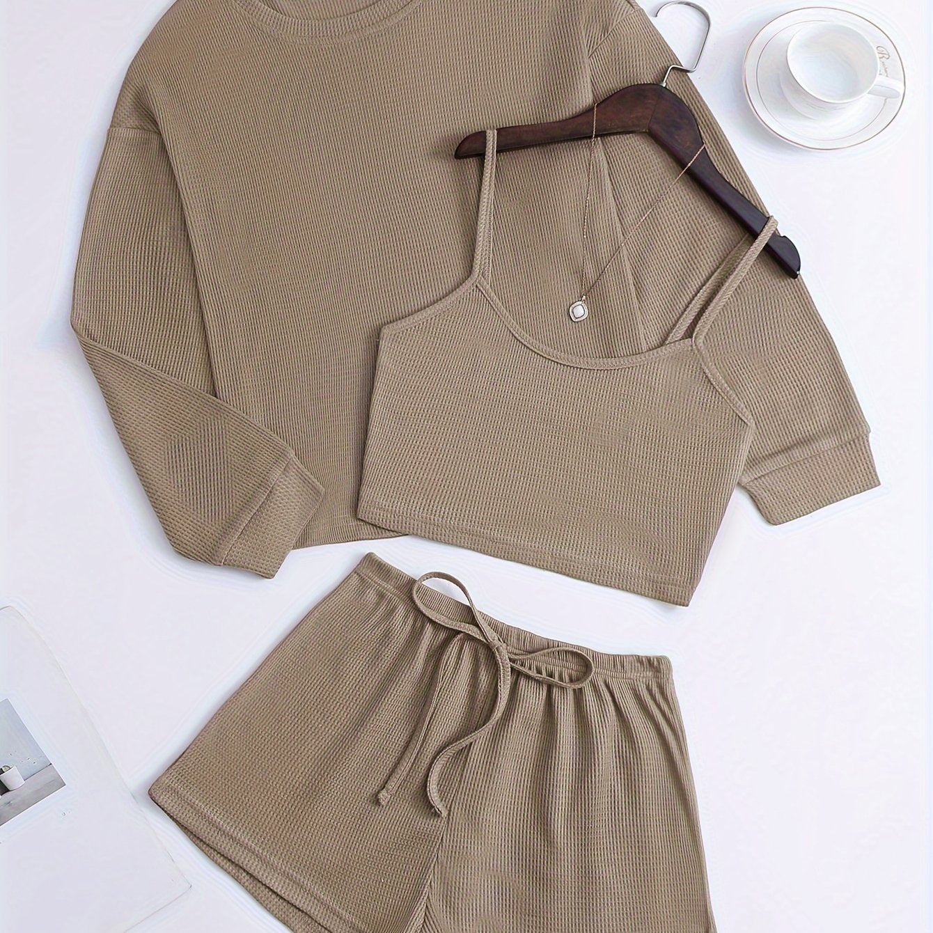 Women's loungewear set with waffle texture, long sleeve top, crop cami, and elastic shorts.