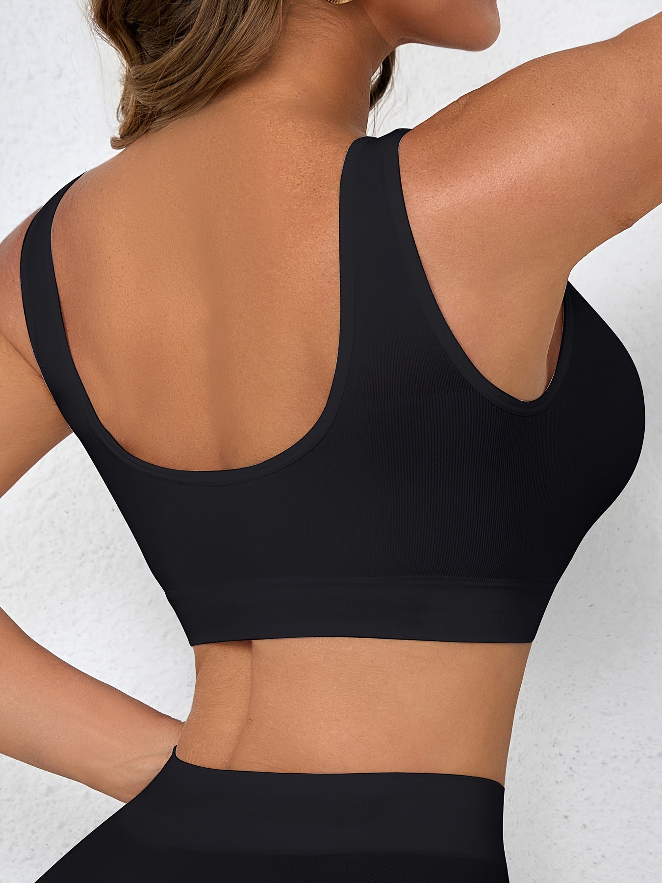 Two women's seamless, high elasticity sports bras made from solid color polyamide knit fabric. Offers high support and does not contain padding. Great for adult athletic activities.