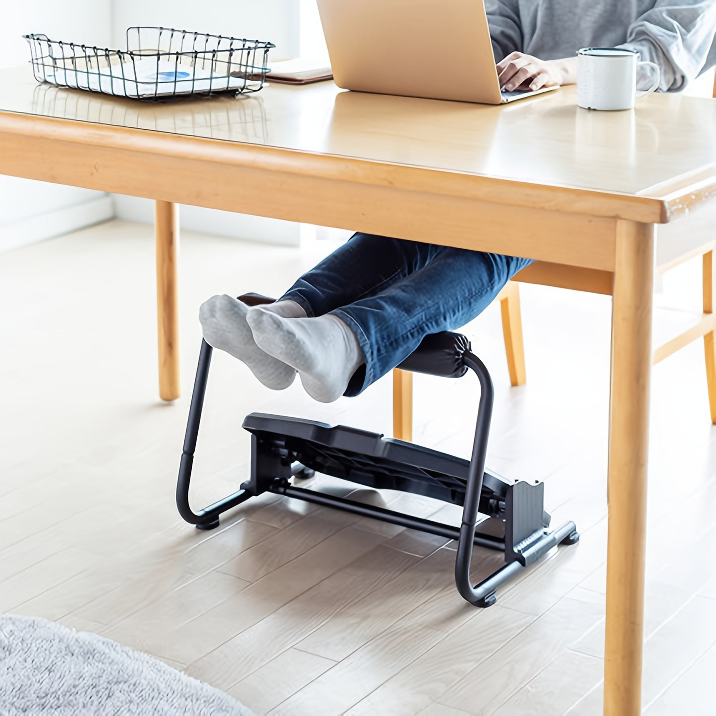 Adjustable ergonomic footrest stool for office use, non-electric, black plastic material.