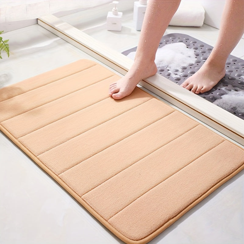 Soft polyester blend bath mat in plush dark gray stripes, featuring a non-slip PVC backing for added safety. Easily machine washable for convenience, this rectangular mat is perfect for adding comfort to your bathroom décor.