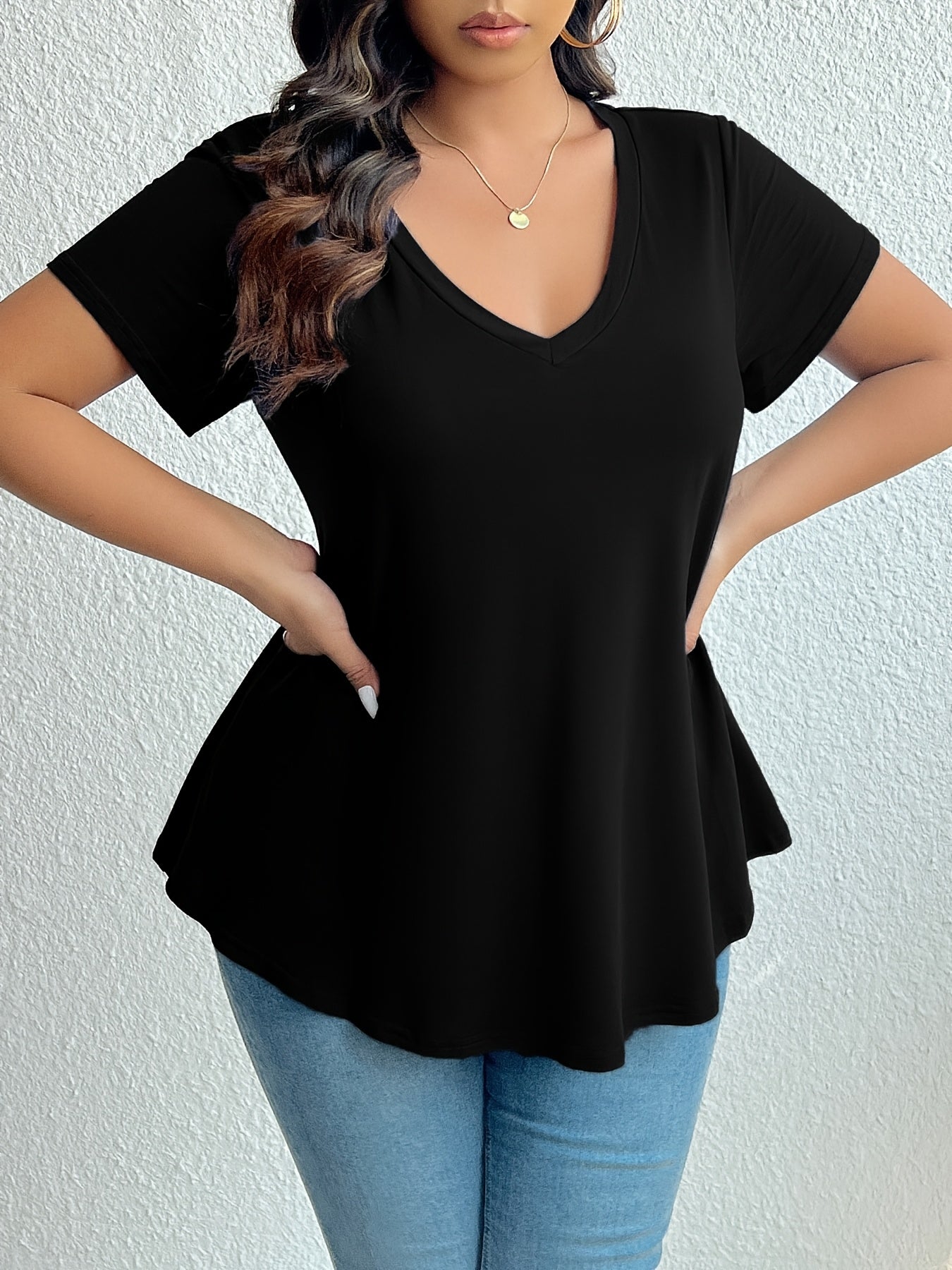 Chic black V-neck t-shirt for plus size women, made from soft polyester and elastane blend. Machine washable and flattering hemline, essential summer wear.