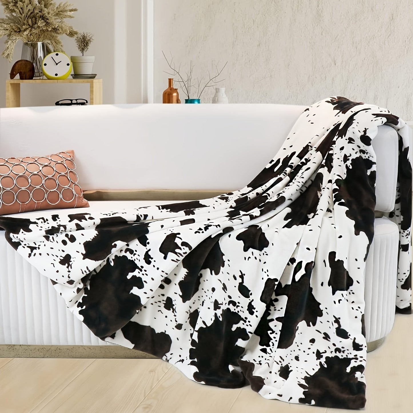 Soft and lightweight, this plush flannel blanket in a cozy cow print is made of 100% polyester for all-season comfort. Perfect for snuggling on the couch or taking on travel adventures, its adorable brown and white design adds a touch of charm to any