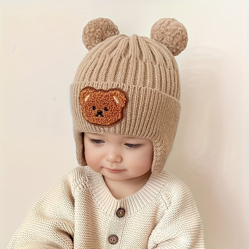 Soft polyester knit hat with cozy bear theme and ear warmers for young children, perfect winter gift for boys and girls aged 0-3 years. Comes in khaki, coffee, and ivory colors.