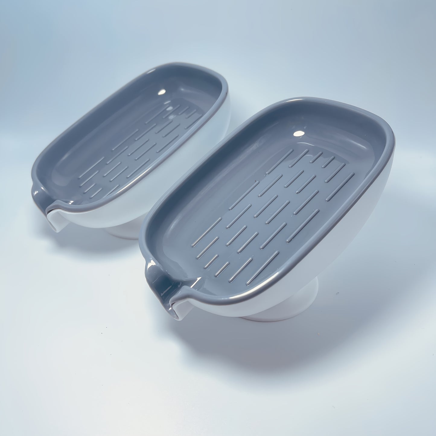 Durable plastic oval soap dish with an elegant, self-draining design for bathroom use.