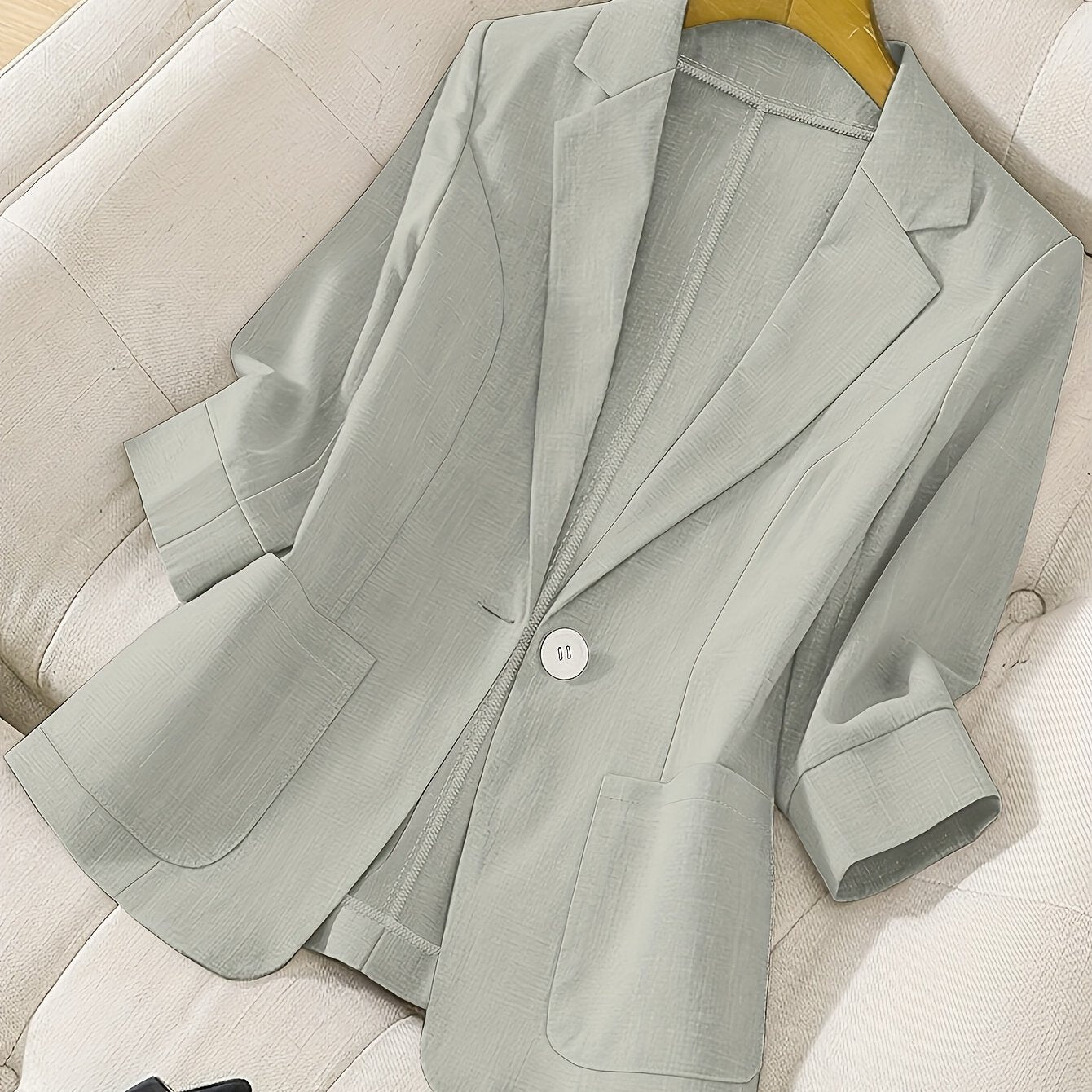 Chic light blue women's blazer with pockets, long sleeves, and notched collar. Made of machine-washable polyester, ideal for spring and summer office casual attire.