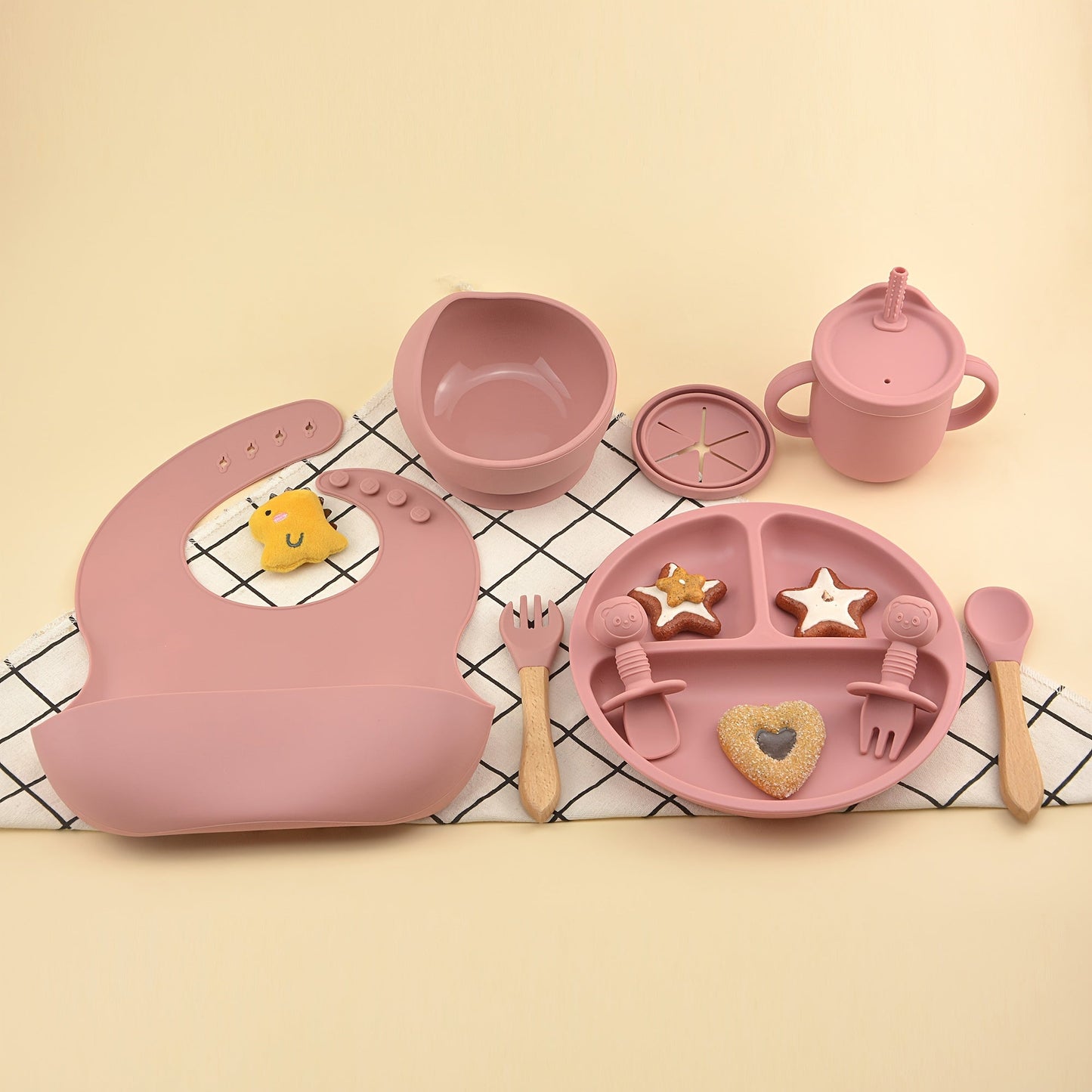 This set includes 9 pieces of feeding cutlery made of food-grade silicone, featuring a silicone bib, suction dinner plate, suction bowl, wooden handle silicone spoon and fork, food supplement spoon and fork, two-in-one drinking training cup, and eating