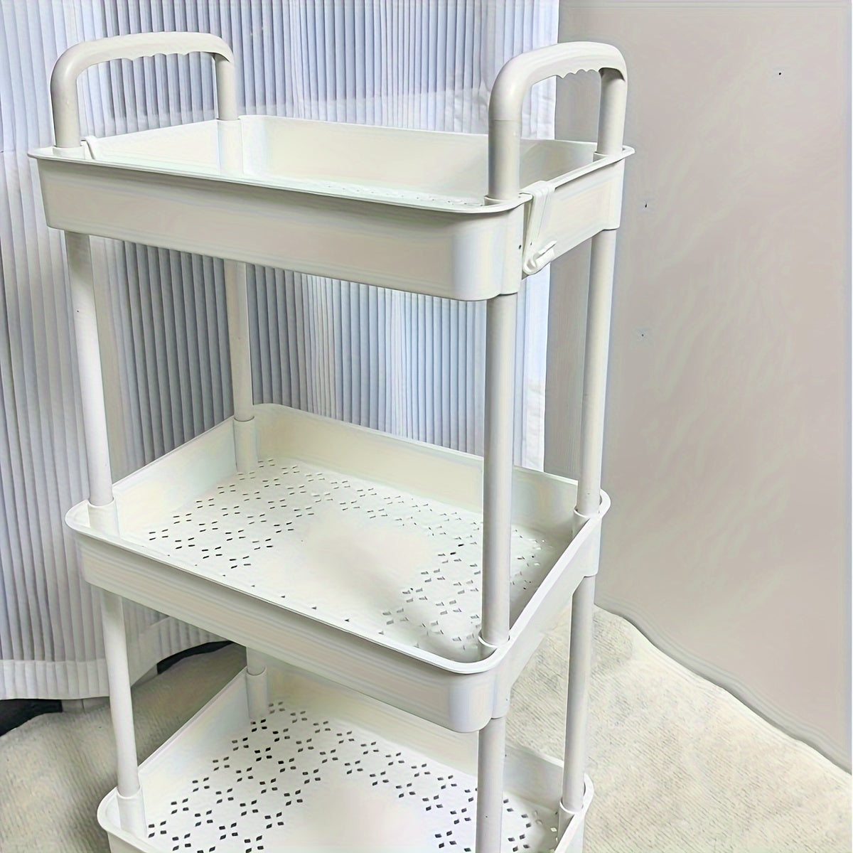 A flexible rolling storage cart on wheels that serves as a multi-tier organizer for snacks and books. Perfect for the kitchen, bedroom, or living room, this space-saving plastic shelving unit is both practical and versatile.