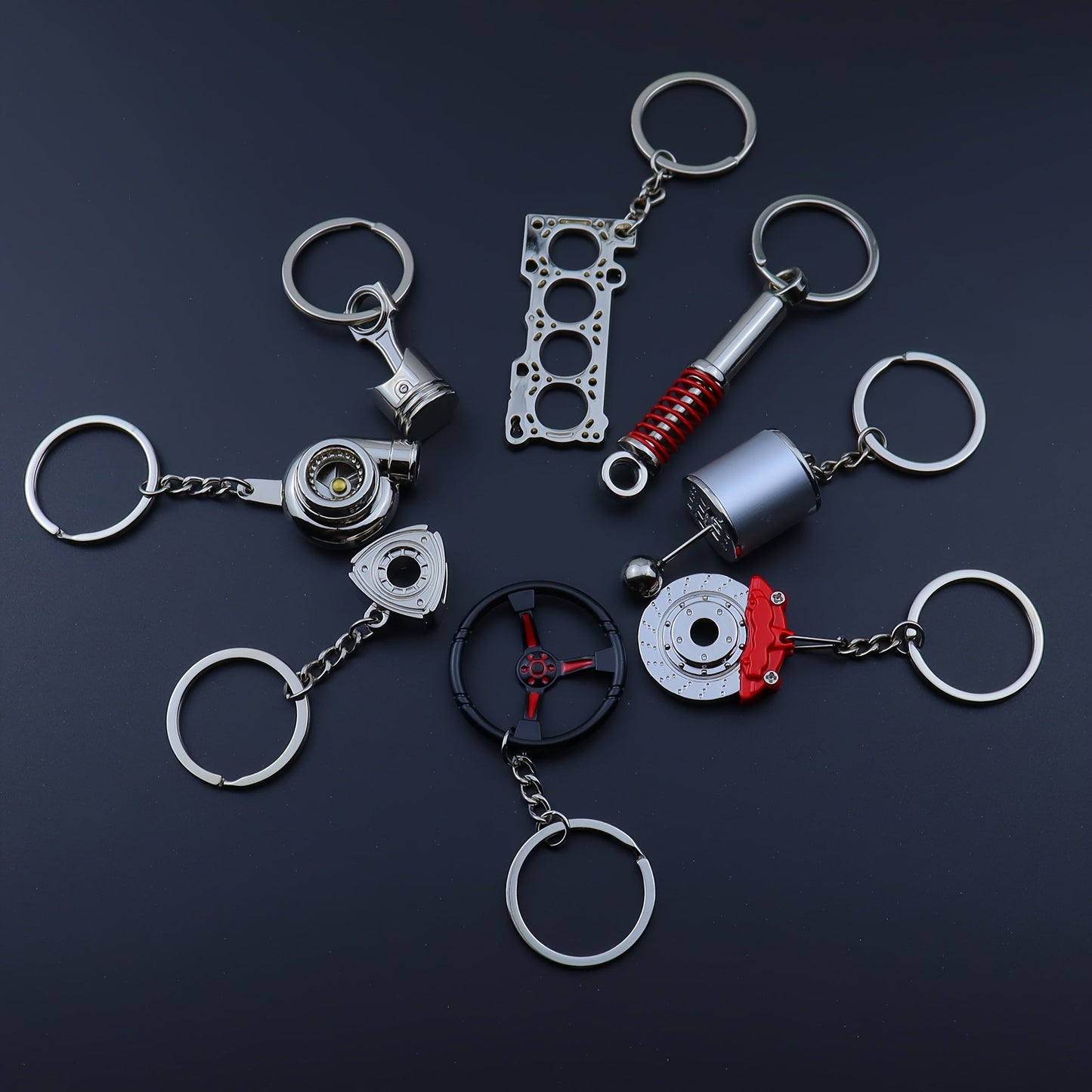 Keychains for creative car modifications, including piston, brake disc, gear, turbocharger, small rotor, shock absorber, engine blade, and steering wheel designs. Perfect for car enthusiasts and as a unique gift.