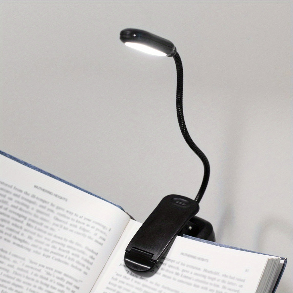 Portable battery-powered clip-on book light with a flexible hose, ideal for reading in small spaces or as a bedside night light.