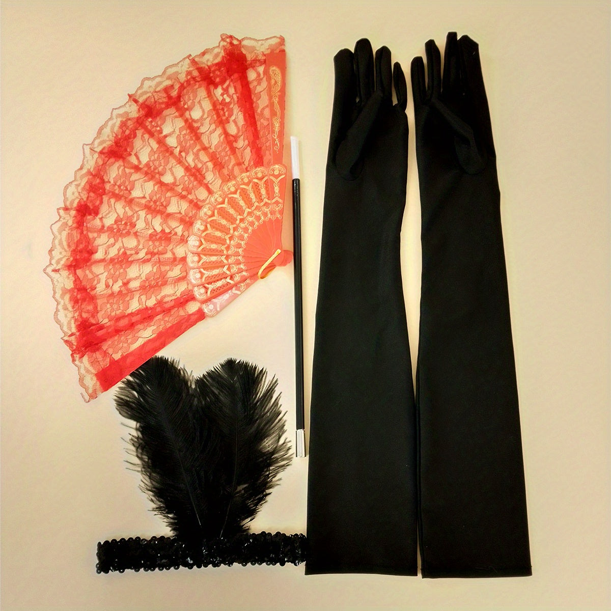 A collection of 1920s masquerade party accessories including gloves, faux feather hair clips, smoke tube fans, and other dress embellishments for women.