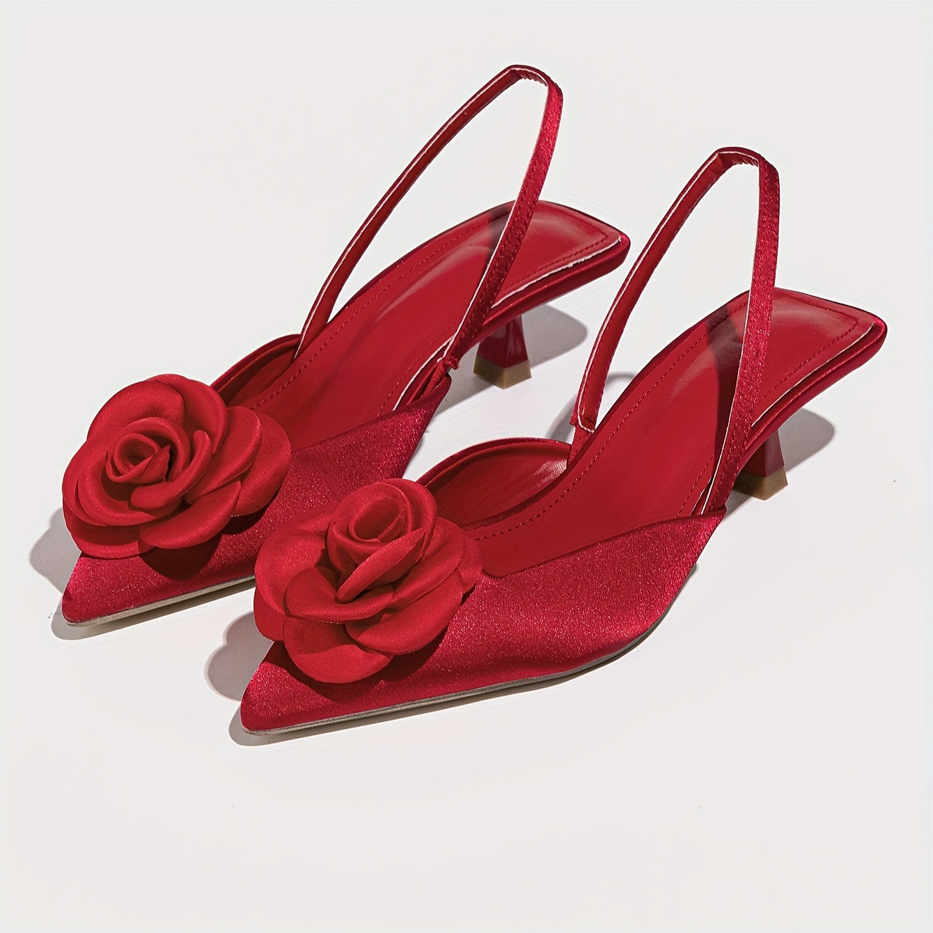 Pointed red high heel shoes with three-dimensional flowers, perfect for night weddings.