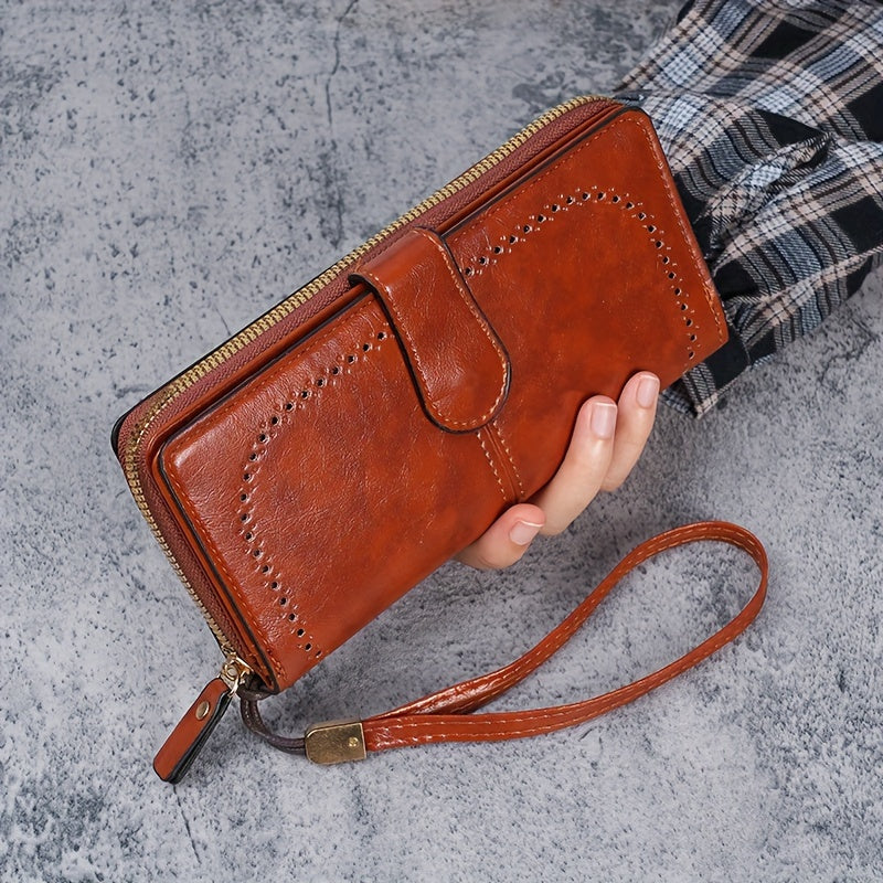 Black faux leather long clutch wallet with wristlet, ID card compartment, button closure, and edge paint. Dry clean only.