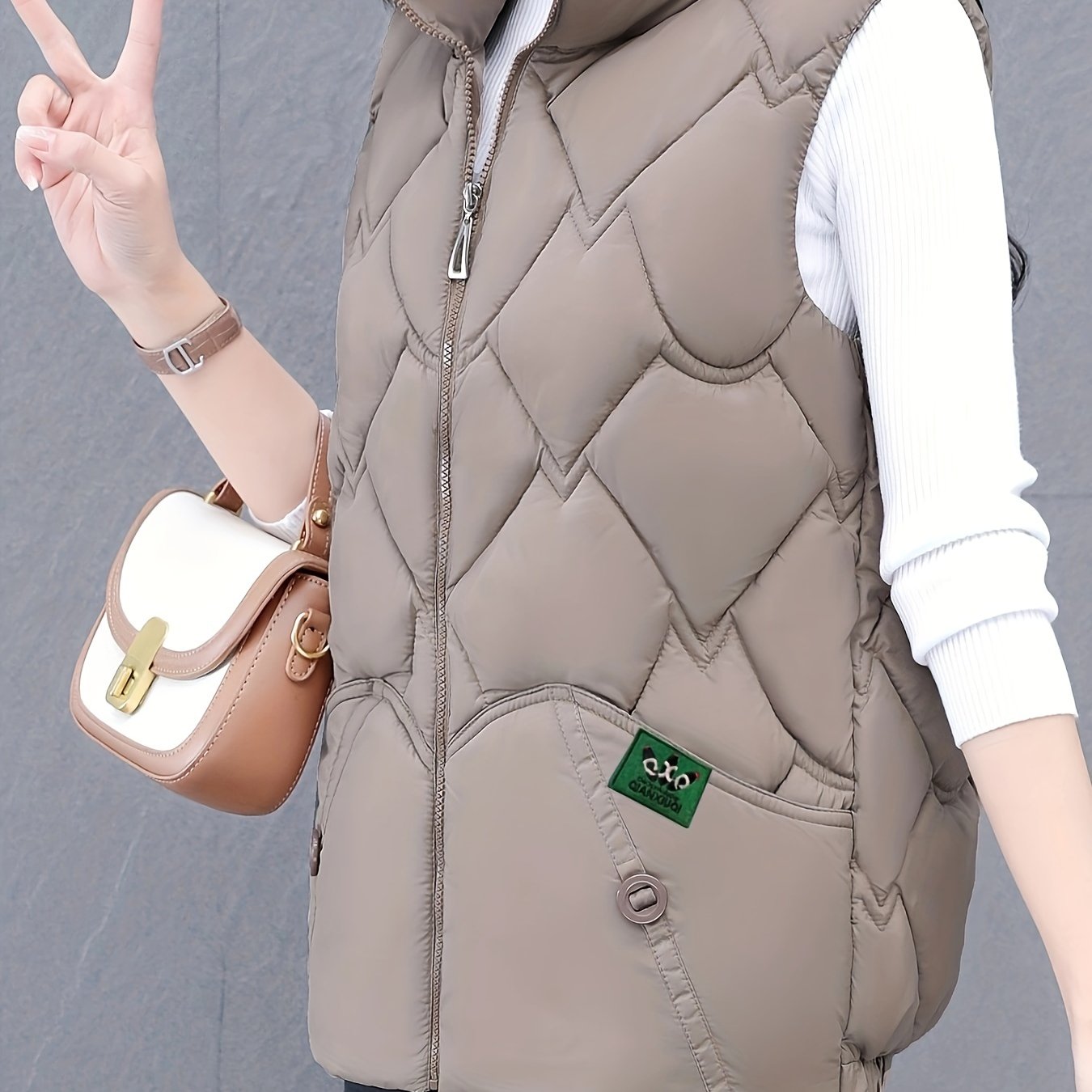 Women's polyester vest with quilted stand collar, zipper closure, pleated hem, and loose fit. Ideal for fall/winter casual wear with a Middle Eastern style.