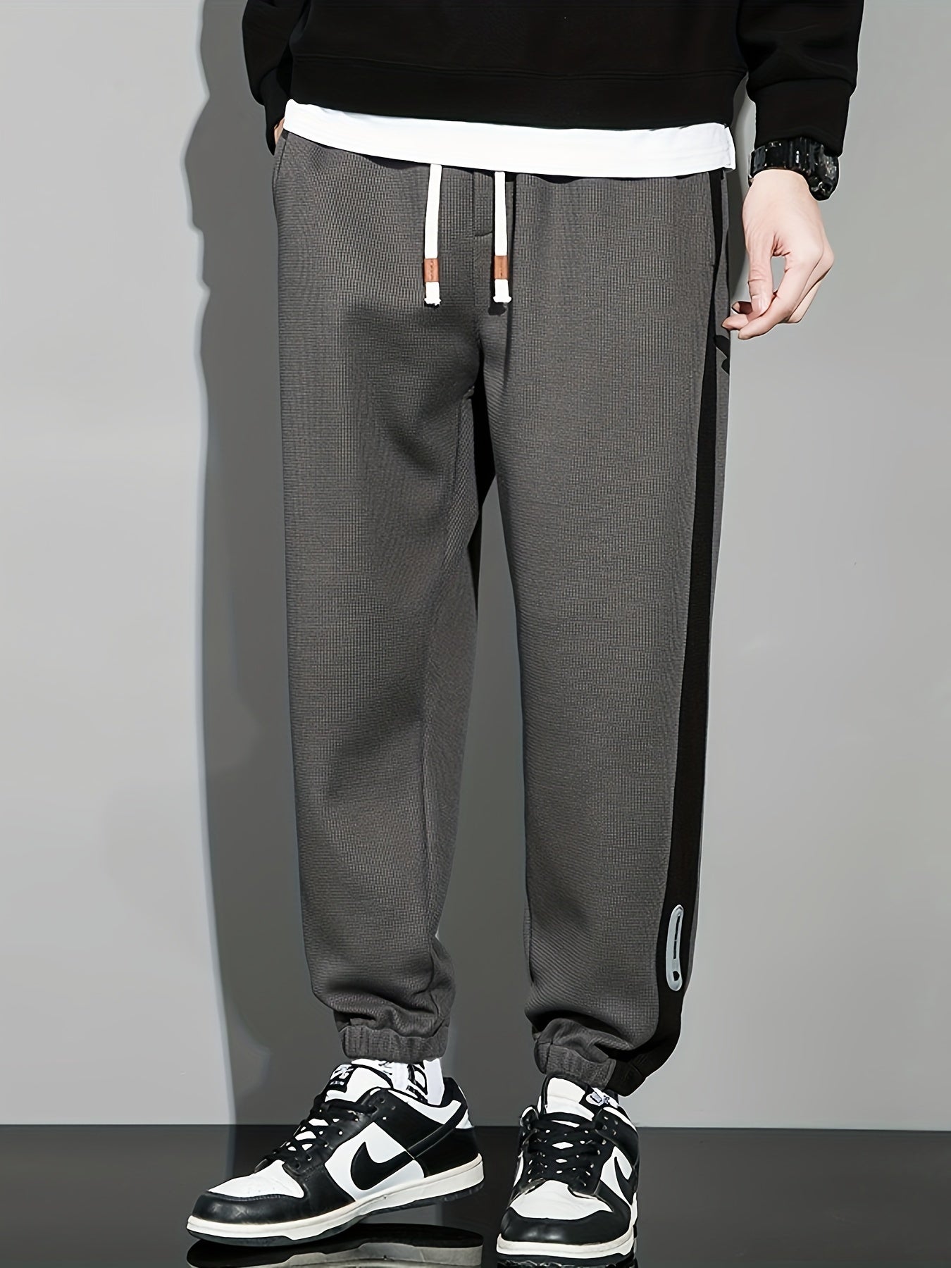 Men's casual joggers with contrast side stripe, elastic waist drawstring, regular fit tapered leg for leisure.