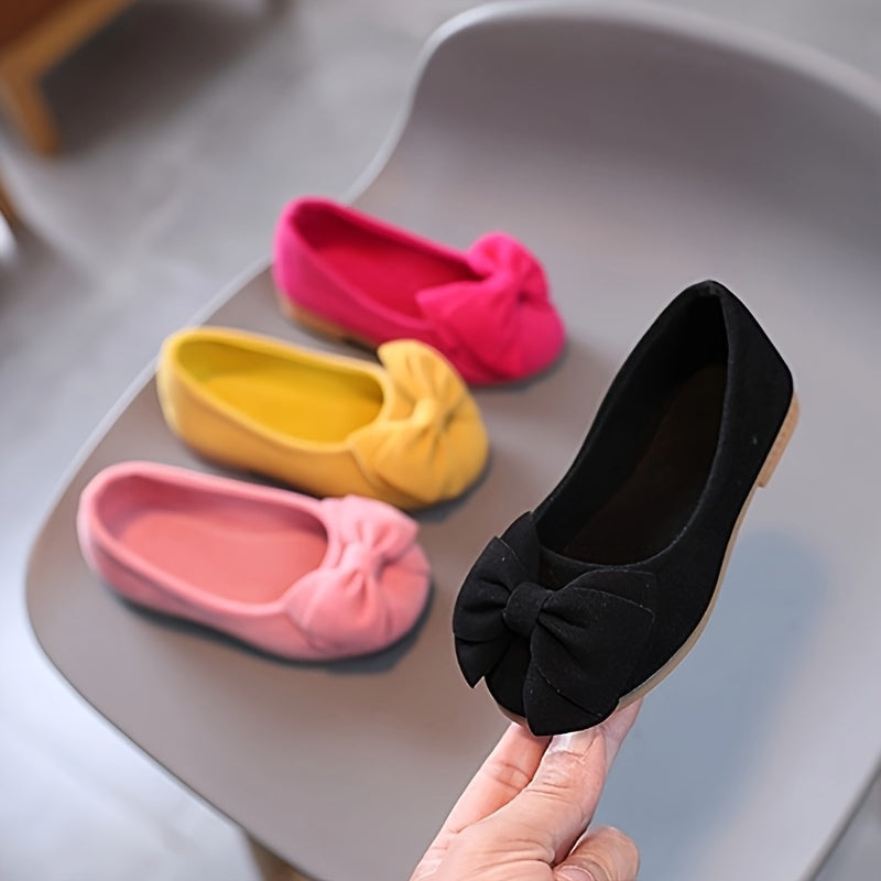 Stylish slip-on princess shoes for chic girls in pink, yellow, and black, with a bow detail. Made of comfy PU fabric with a rubber sole. Easy slip-on design for casual attire and