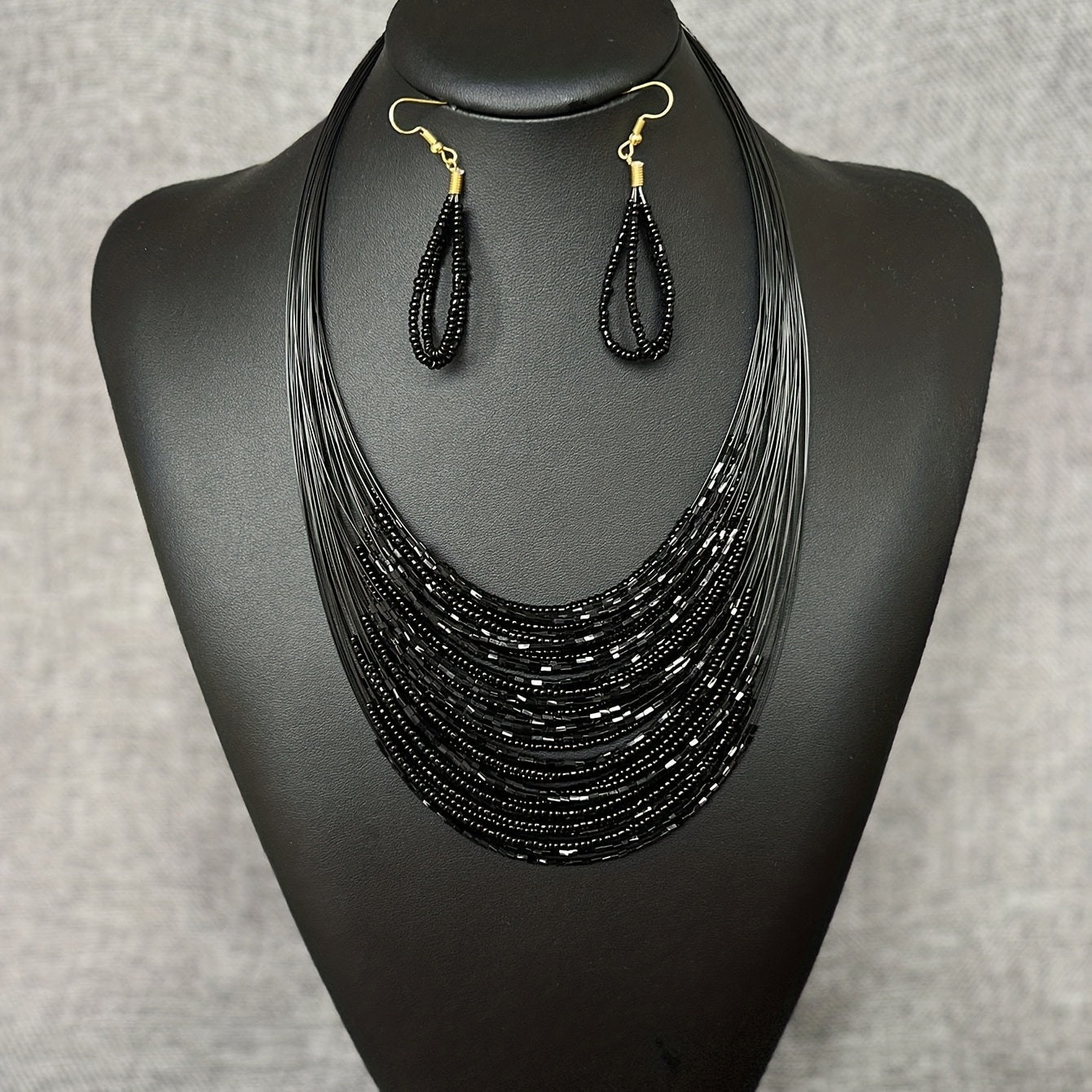 A set of three handmade earrings and a necklace crafted from elegant black beads in a multi-layer design, representing both evil and mystery. Perfect accessories to complete your daily outfits or add flair to your party attire.