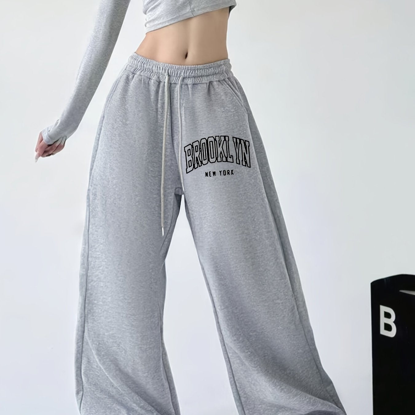 Women's casual joggers with letter print, drawstring elastic waist, pockets, and hip-hop streetwear style.