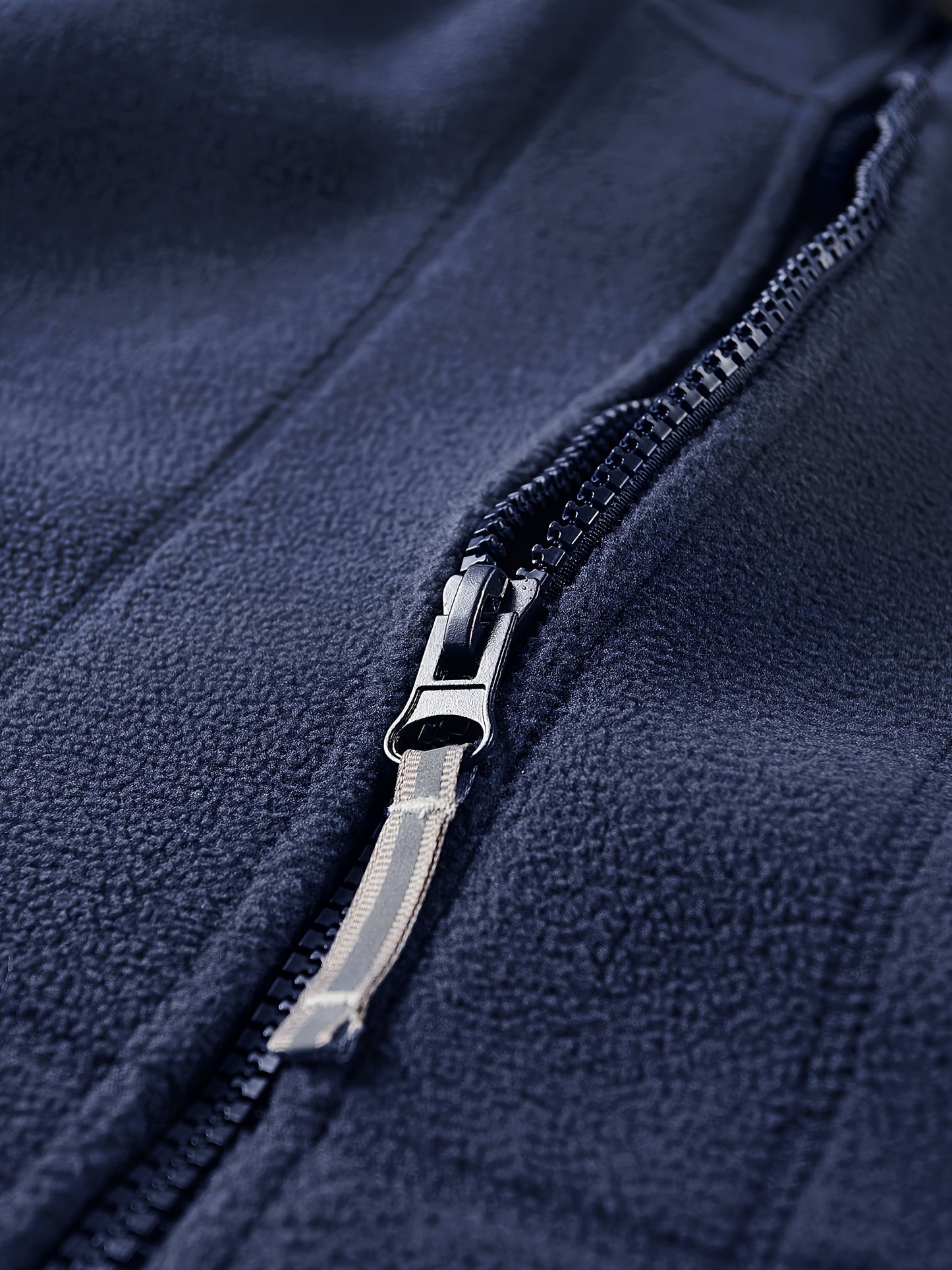 Men's fleece-lined hooded jacket for fall/winter activities, featuring windproof design, zipper pockets, and embroidery details.