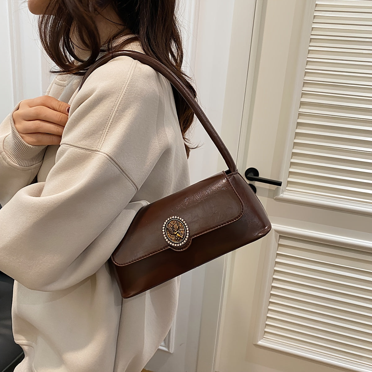 French vintage-style shoulder bag for women in elegant brown, with metal emblem, magnetic closure, and polyester lining. Versatile and stylish for daily use.