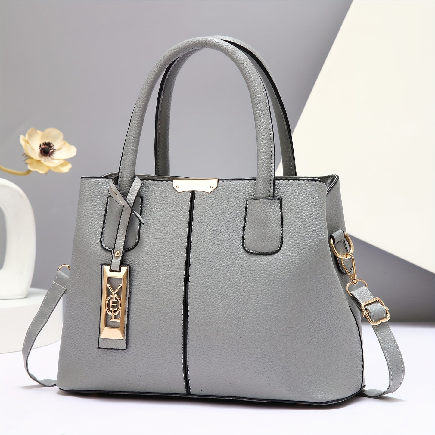 Gray PU tote bag with adjustable straps and zip closure; versatile as shoulder or crossbody bag with spacious capacity and polyester lining.