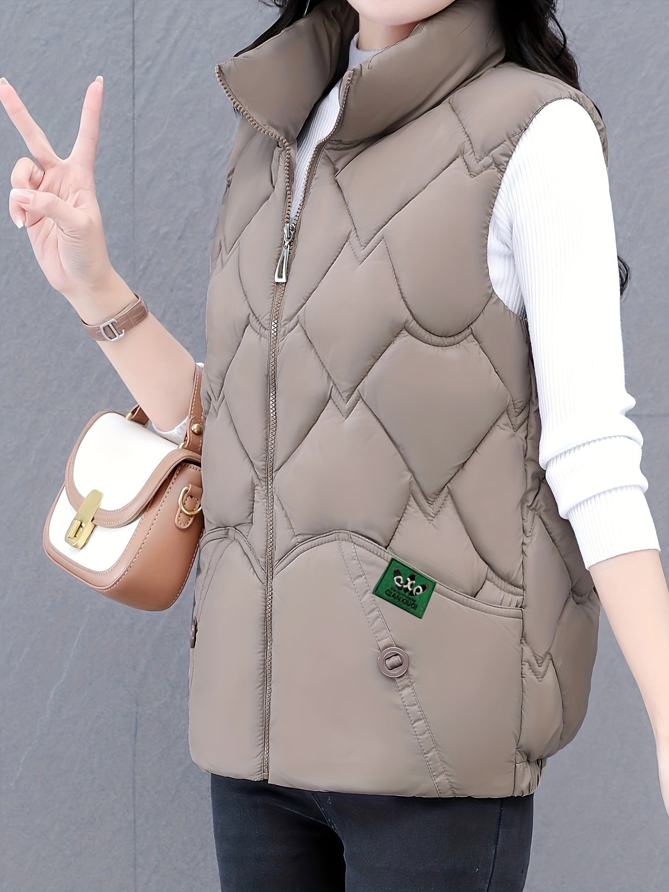 Women's polyester vest with quilted stand collar, zipper closure, pleated hem, and loose fit. Ideal for fall/winter casual wear with a Middle Eastern style.