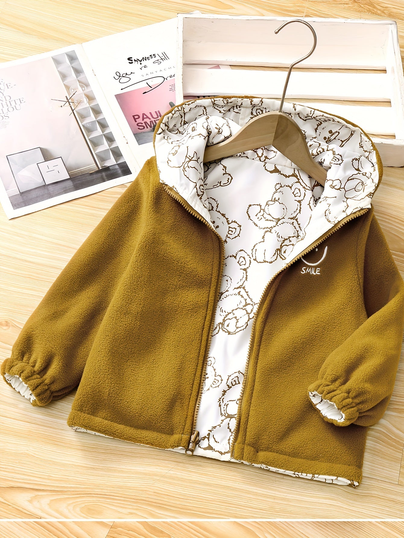 Kids' reversible hooded jacket featuring a cute bear pattern, fleece-lined for warmth in fall/winter. Made of polyester with pockets.