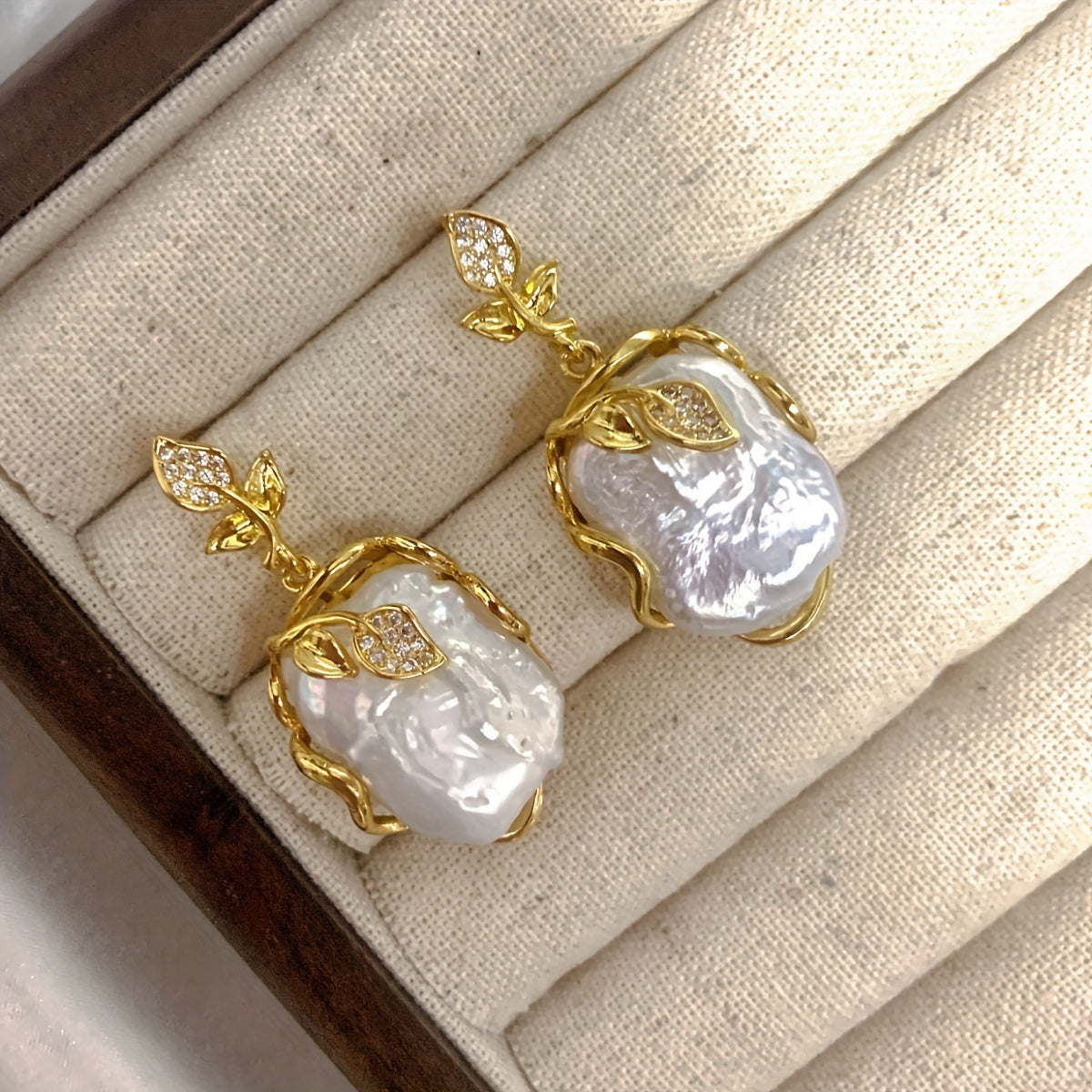 Elegant and luxurious French-inspired freshwater pearl earrings with gold-plated silver leaf accents, perfect for fashion-forward women with a taste for retro style and natural beauty.