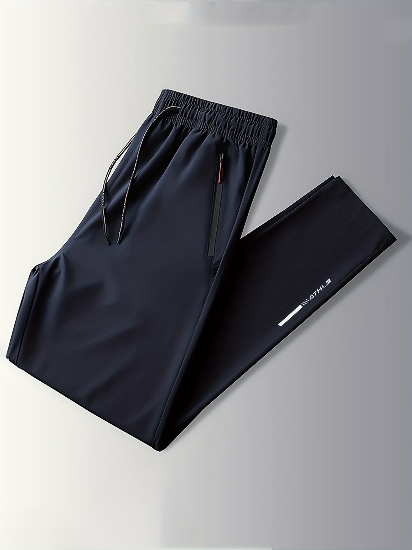 Three-pack of men's plus size track pants made of 100% polyester with a slight stretch, regular fit, woven fabric, print pattern, and zipper detail.