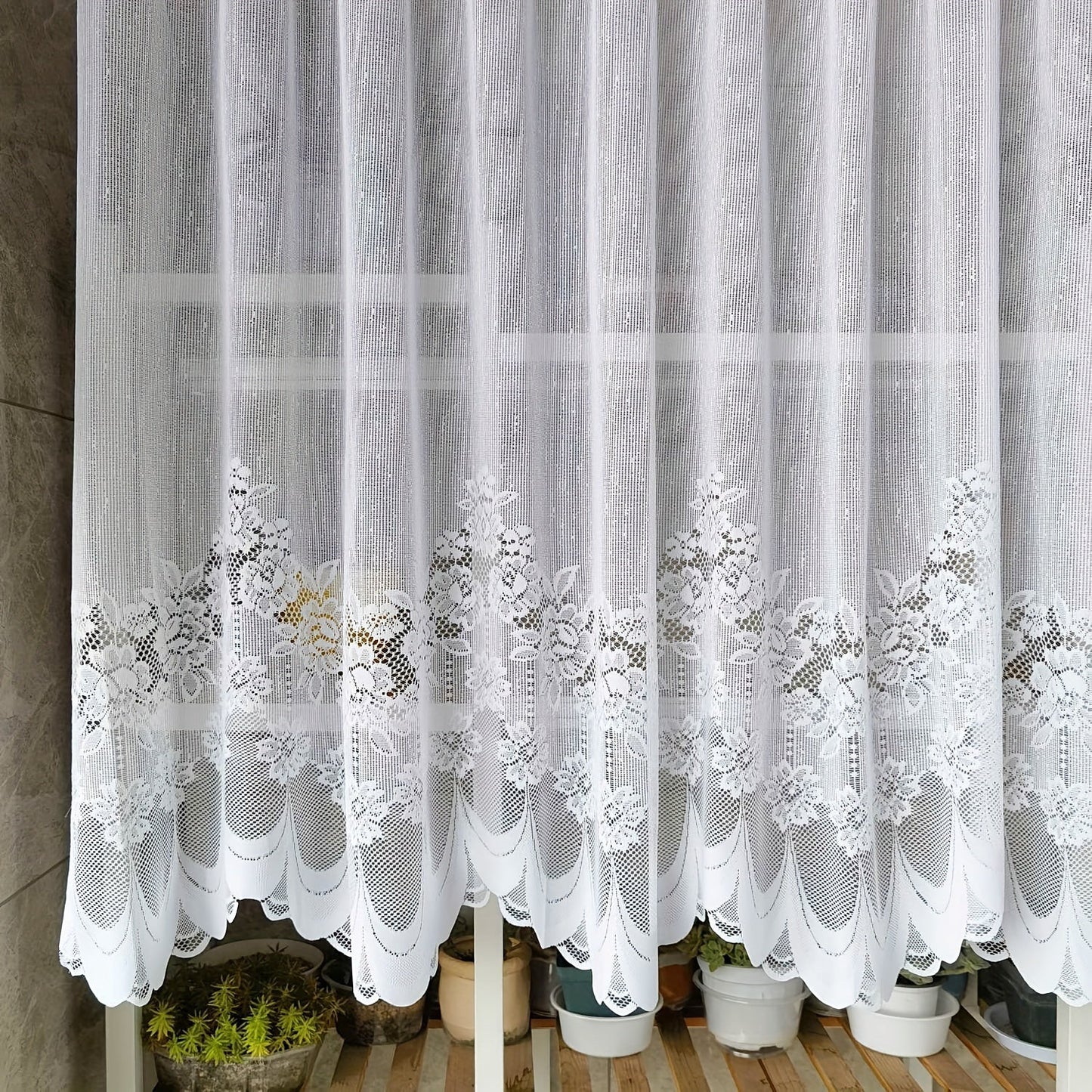 Bring elegance to your windows with our 1-piece White Lace Sheer Curtain featuring delicate floral patterns. This curtain has a rod pocket, scalloped bottom, and is made of lightweight polyester voile, perfect for dining rooms and kitchens. It is