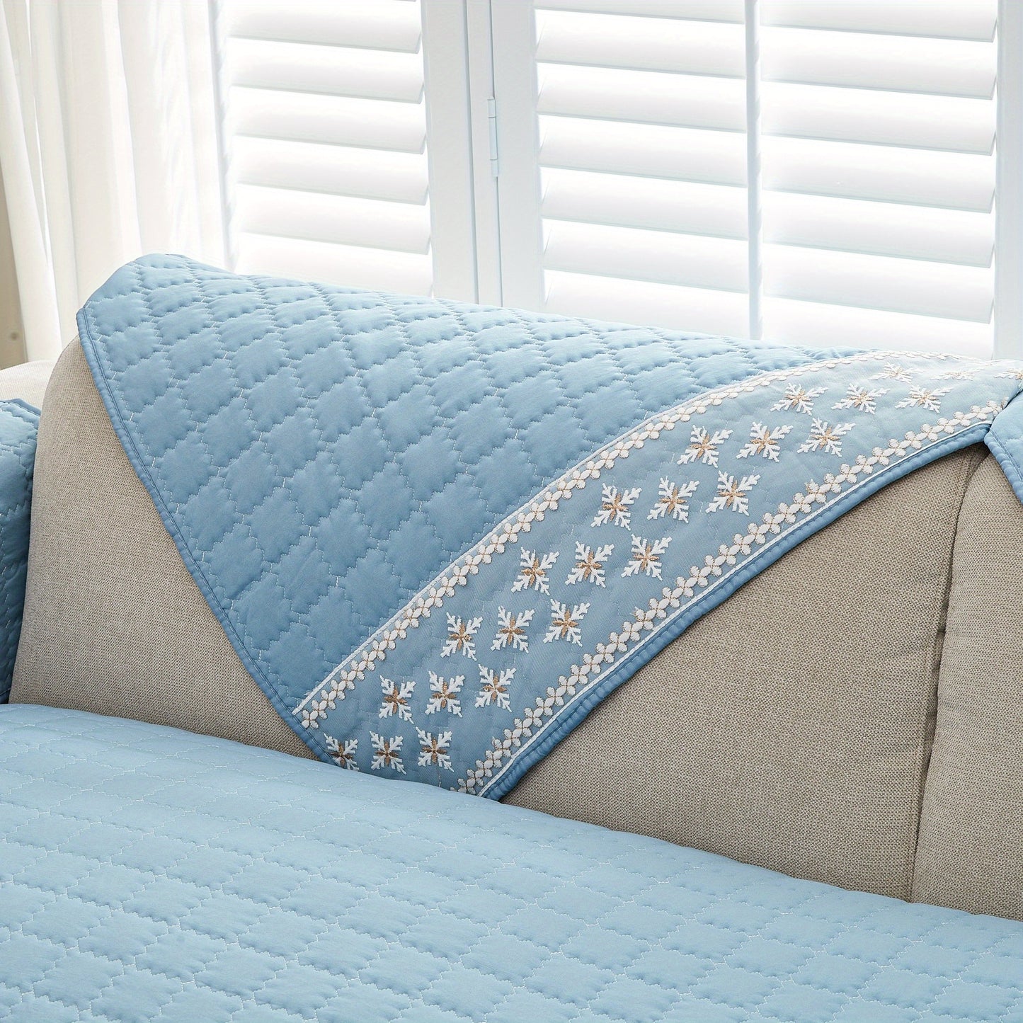 Waffle quilting sofa cover with snowflake lace decor and anti-slip backing.