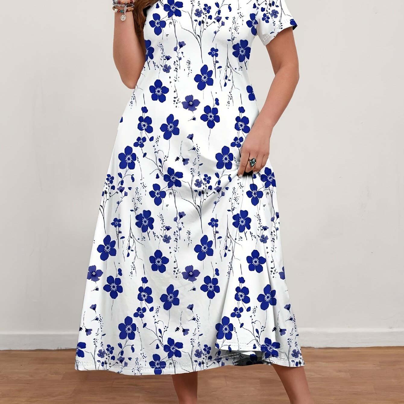 Ankle-length white dress with blue floral print, short sleeves, V-neck, ruffled hem, stretchy polyester blend, machine washable, plus size.