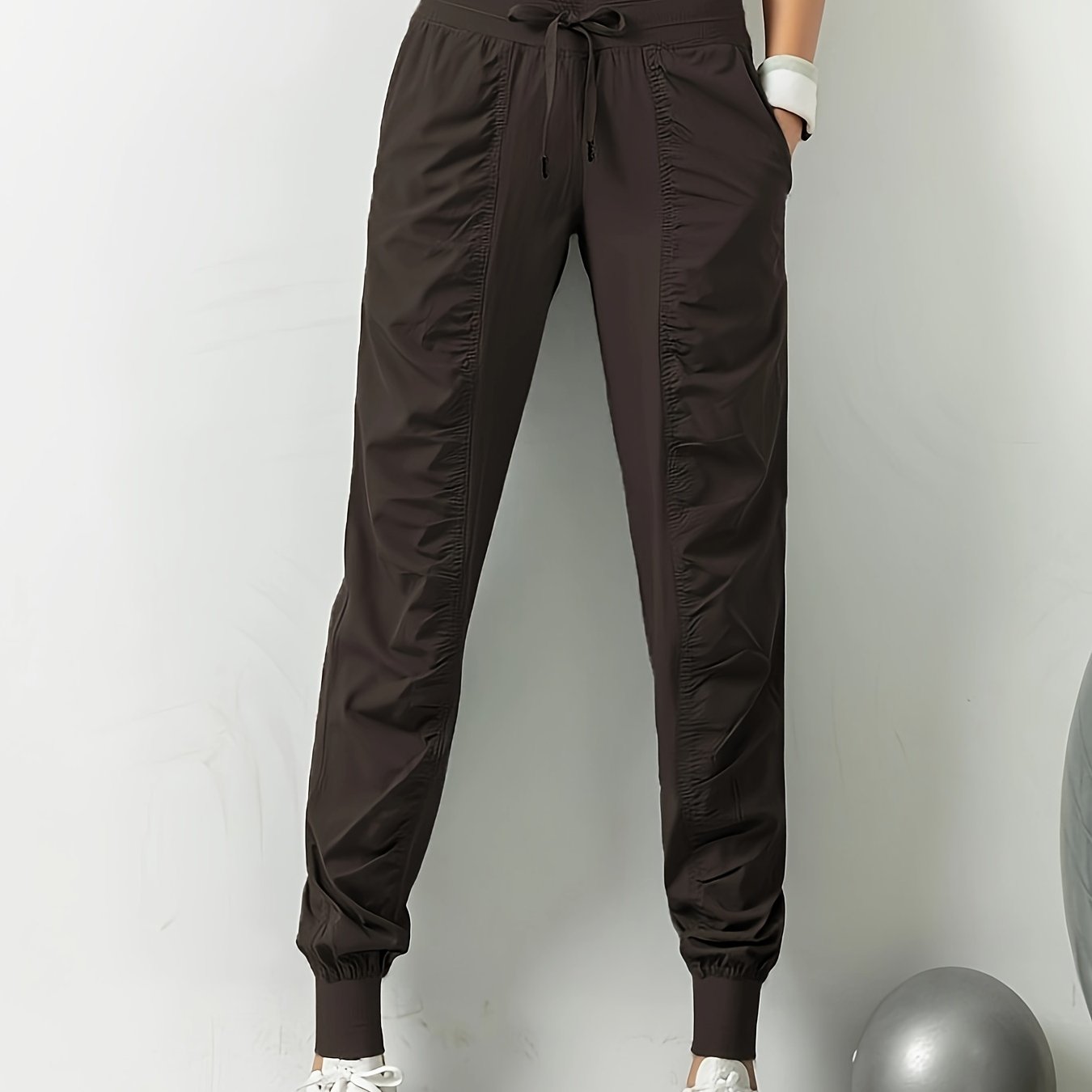 Women's solid color sports pants with drawstring waist, quick drying material, and side pockets for casual comfort.