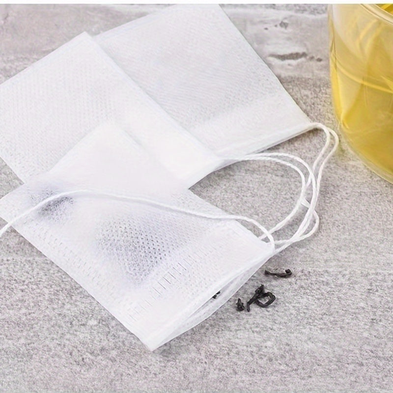 100 pieces of disposable tea filter bags made of plastic with drawstring, designed to be filled with loose leaf herbs and spices for infusion.