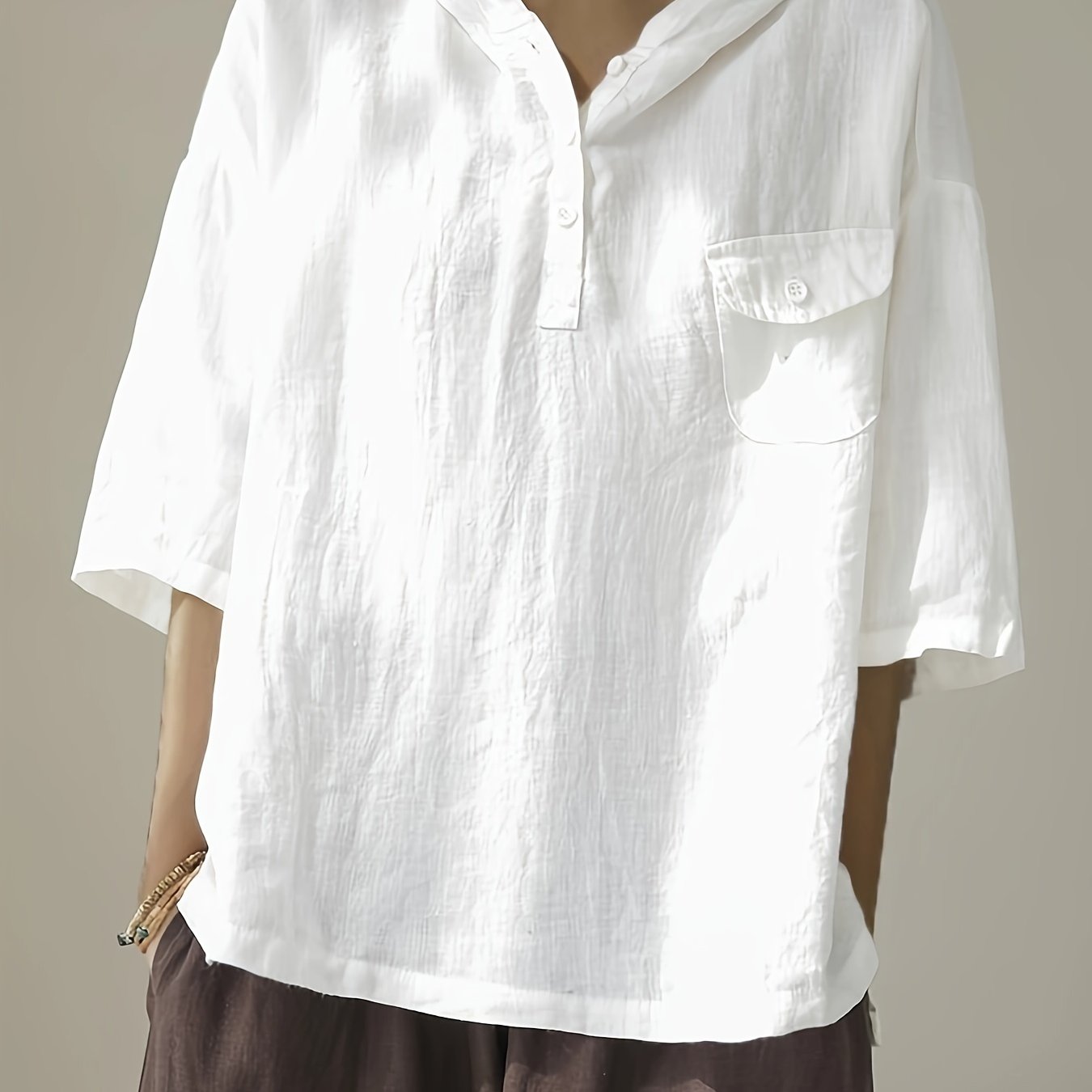 Loose-fitting short-sleeve top with hood and button closure.