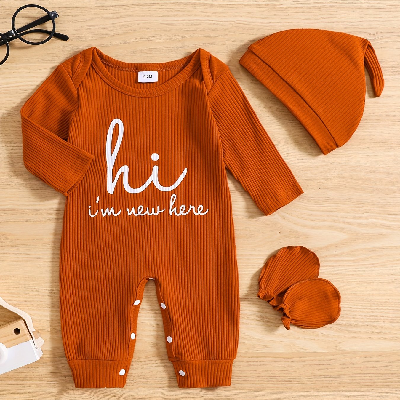 Newborns' "Hi I'm New Here" outfit: long-sleeve romper, hat, and gloves for boys and girls for outdoor wear.