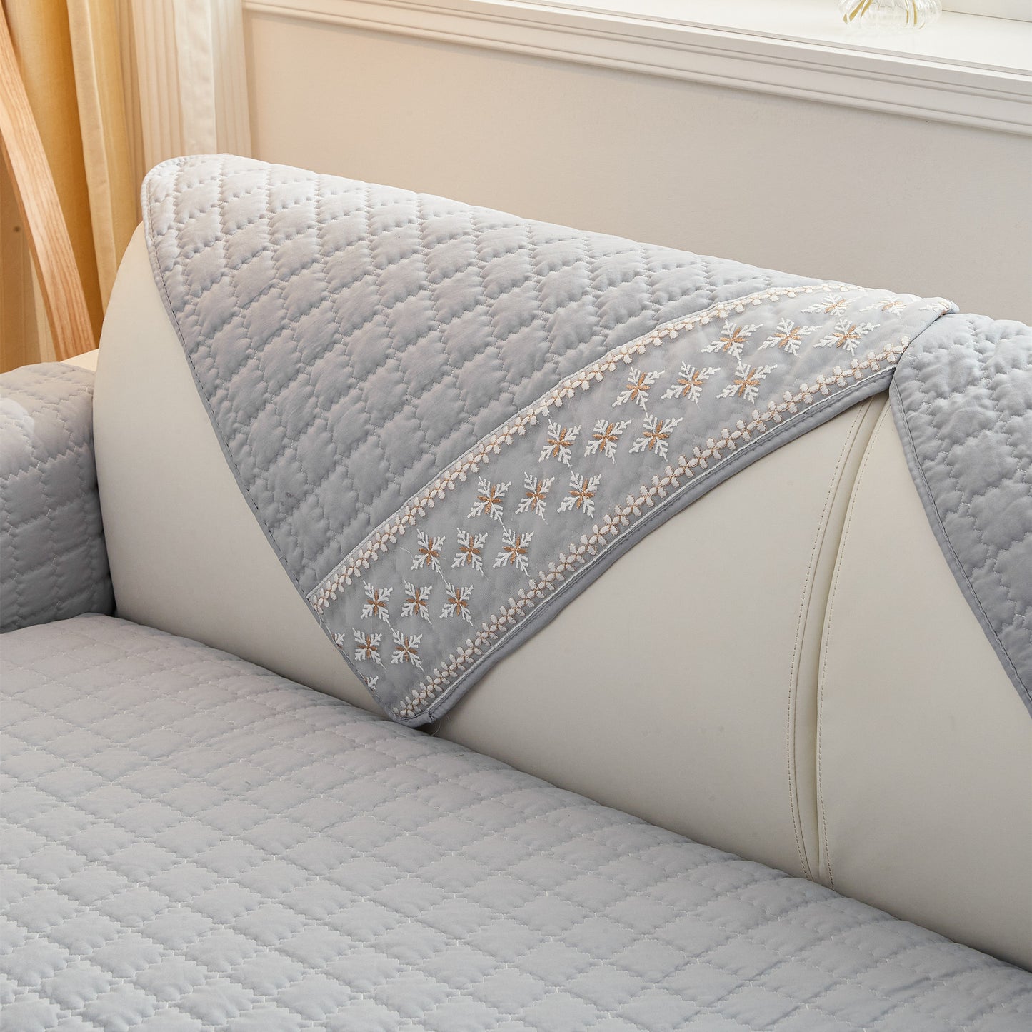 Waffle quilting sofa cover with snowflake lace decor and anti-slip backing.