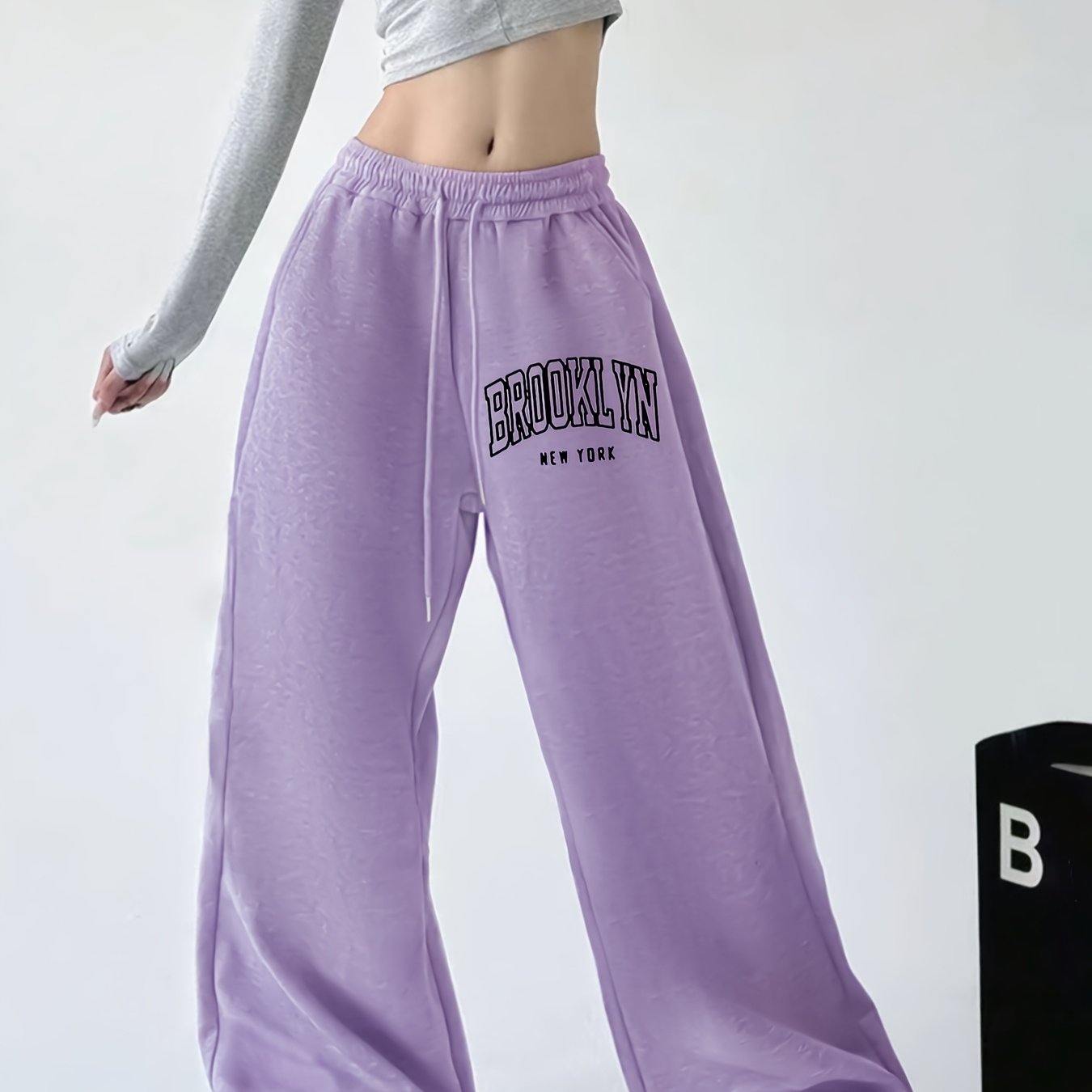 Women's casual joggers with letter print, drawstring elastic waist, pockets, and hip-hop streetwear style.