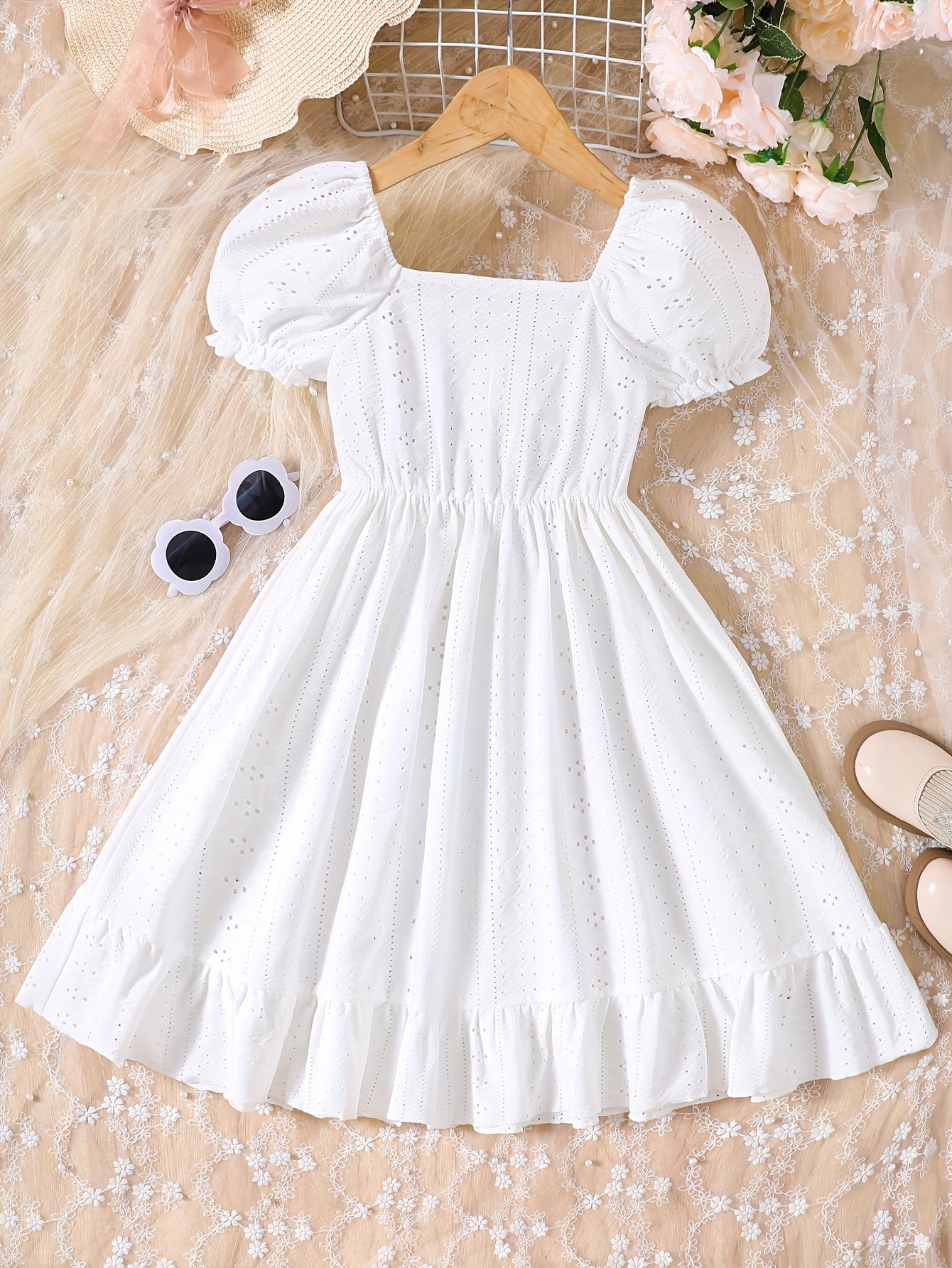 Sweet knit summer dress with charming eyelet jacquard, puff sleeves, and ruffle hem. Casual button-front white dress for young girls.