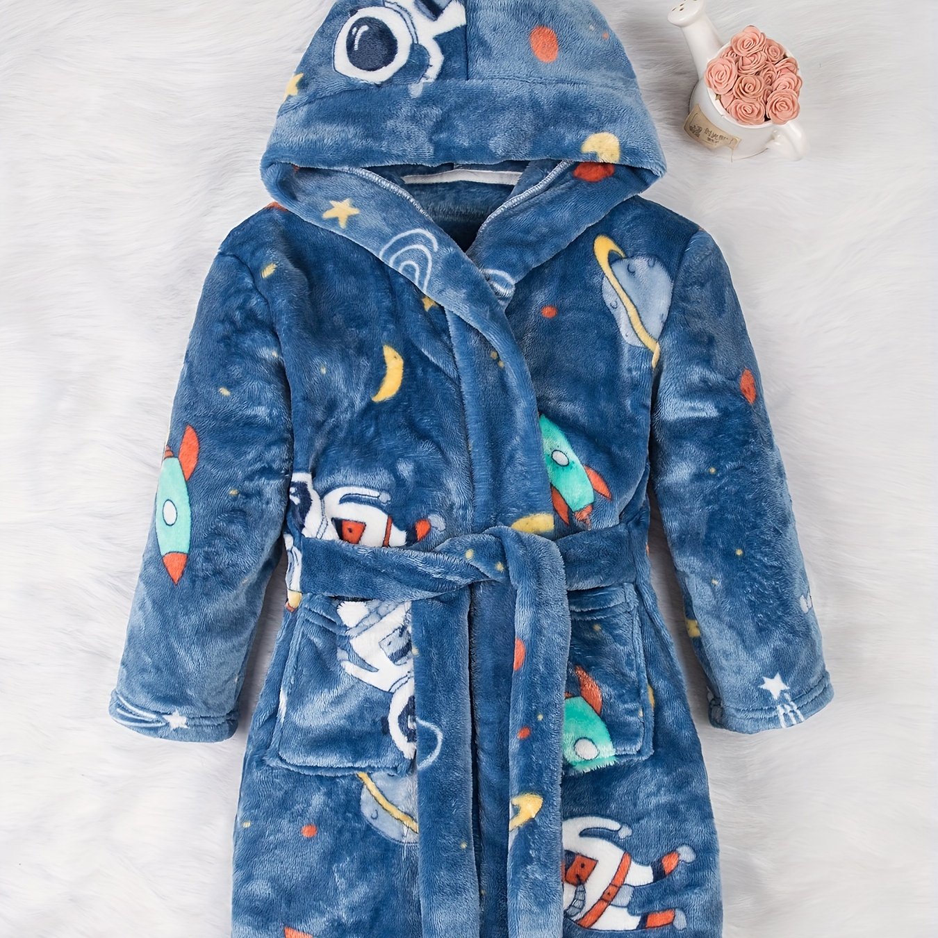 Soft and cozy space-themed boys' fleece robe with flame retardant technology. Features long sleeves, hood, pockets, and is machine washable. Ideal for home and party wear, perfect gift for